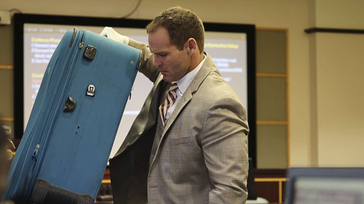 Prosecutor Dave Cacciatore Jr. takes out the suitcase in evidence Friday at the Orange County Courthouse in Orlando, Fla. Sarah Boone has been found guilty of murder for leaving her boyfriend to die after he was zipped into a suitcase.