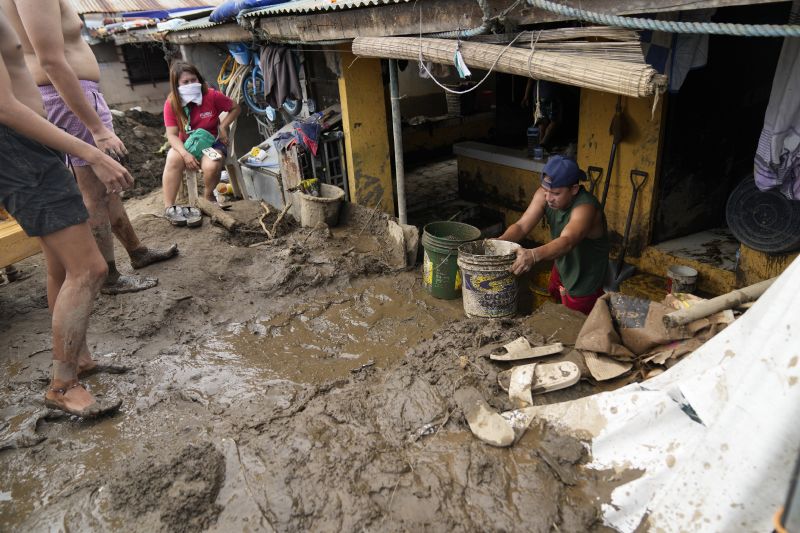 Residents clear out mud from their homes after a landslide triggered by Tropical Storm Trami recently struck Talisay, Batangas province, Philippines, Saturday.