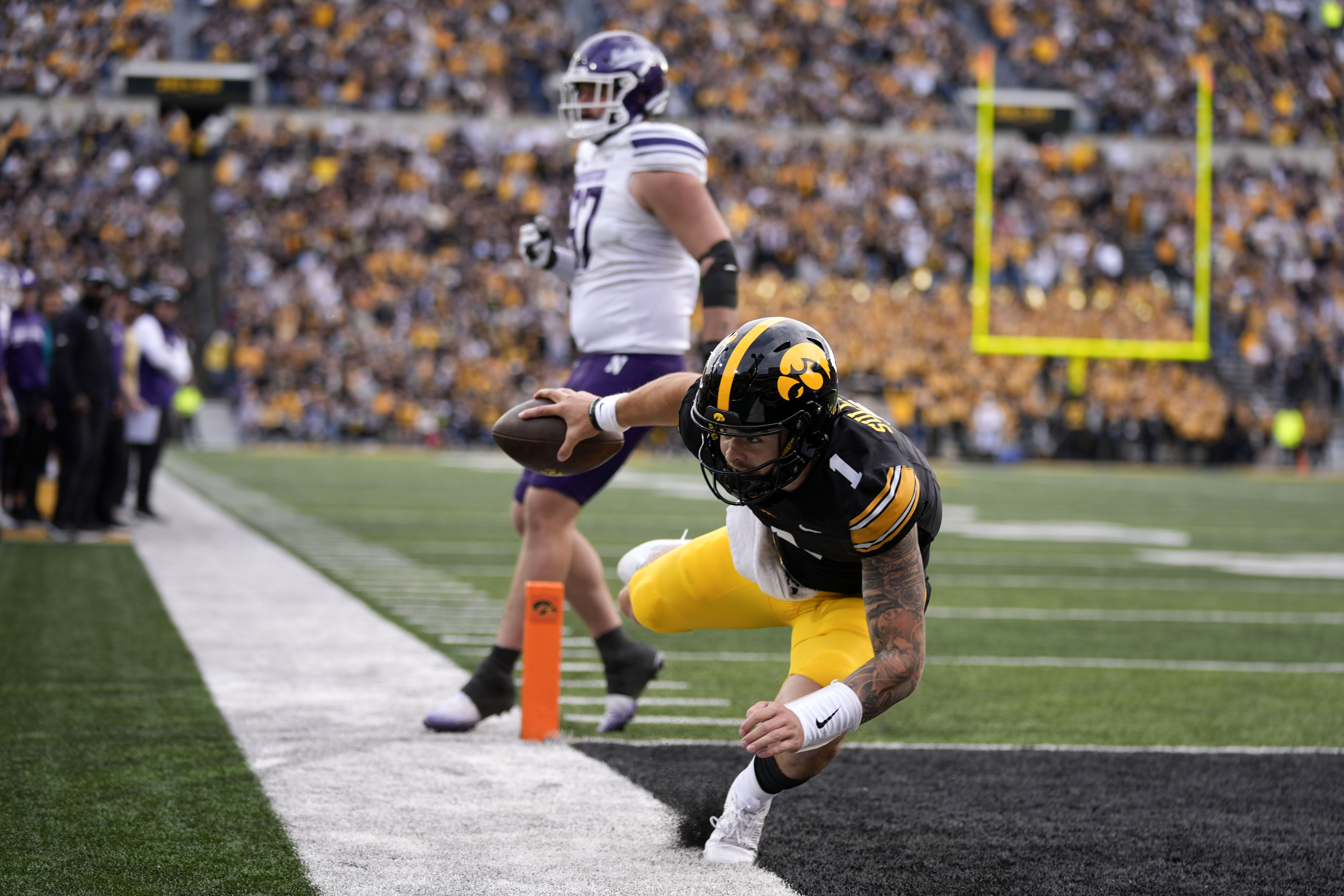 Iowa quarterback Brendan Sullivan (1) scores on a 6-yard touchdown run during the second half of an NCAA college football game against Northwestern, Saturday, Oct. 26, 2024, in Iowa City, Iowa. 