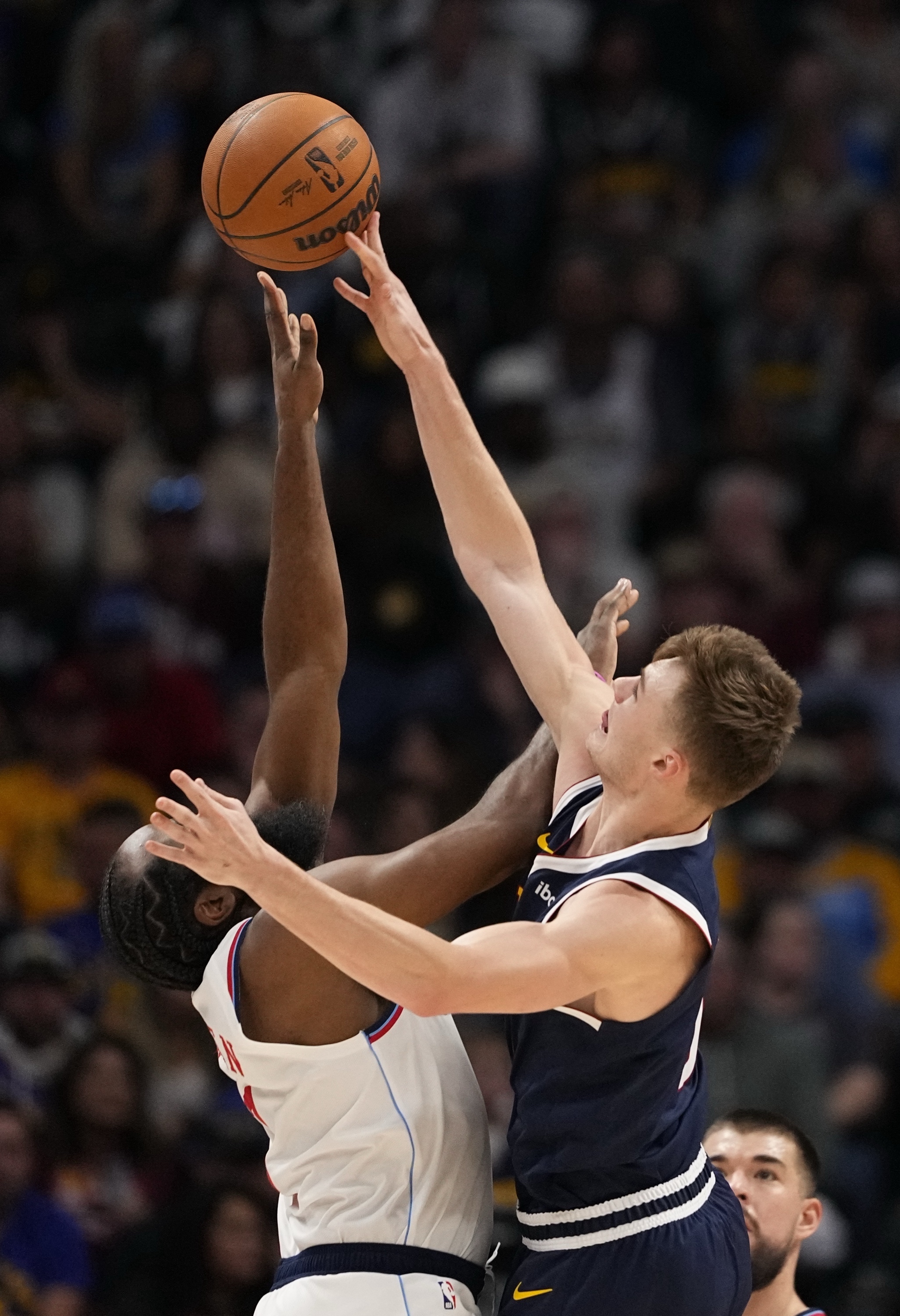 Denver Nuggets guard Christian Braun (0) blocks a shot by Los Angeles Clippers guard James Harden (1) during the first half of an NBA basketball game Saturday, Oct. 26, 2024, in Denver. 