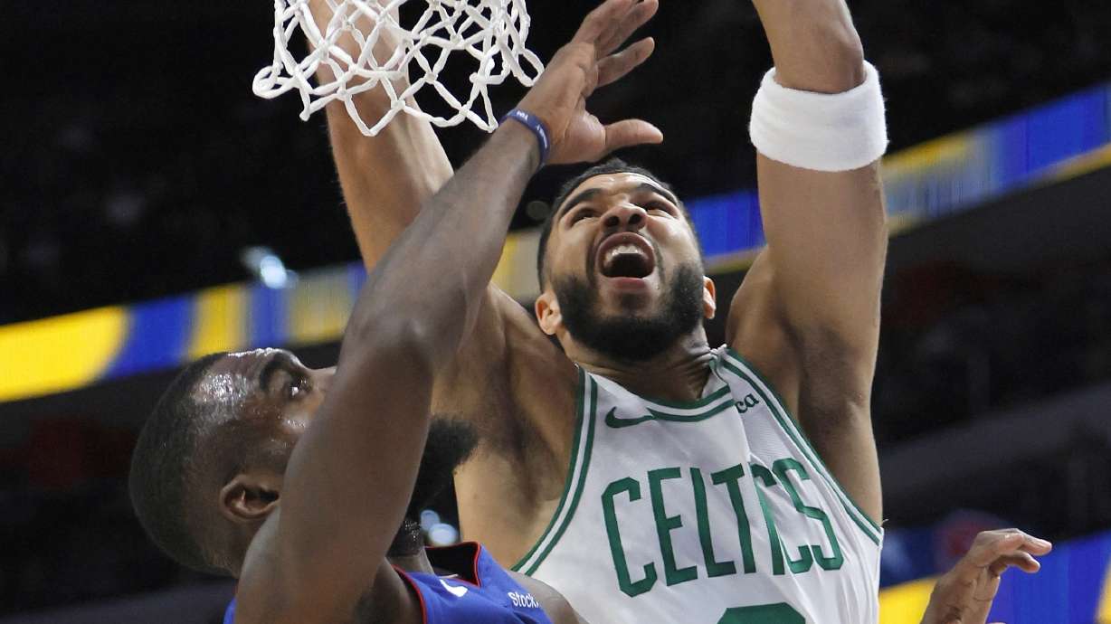 Boston Celtics forward Jayson Tatum (0) dunks over Detroit Pistons forward Tim Hardaway Jr. (8) during the first half of an NBA basketball game Saturday, Oct. 26, 2024, in Detroit.