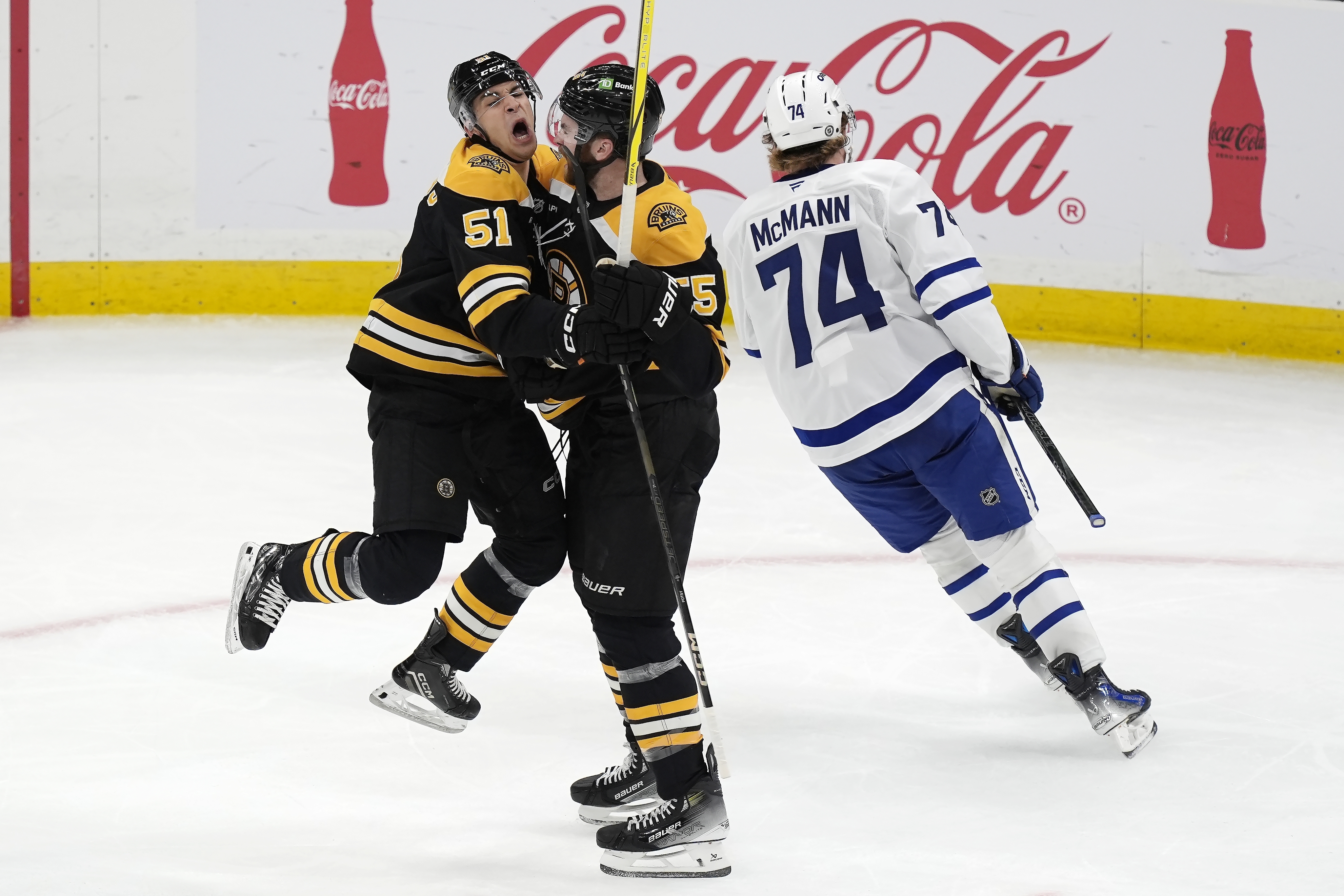 Boston Bruins' Justin Brazeau (55) celebrates his goal with Matthew Poitras (51) as Toronto Maple Leafs' Bobby McMann (74) skates away during the second period of an NHL hockey game, Saturday, Oct. 26, 2024, in Boston. 