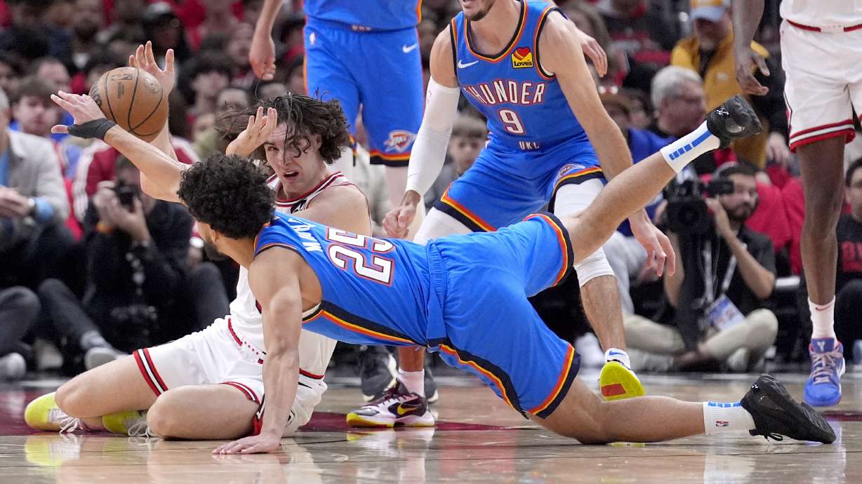 Oklahoma City Thunder's Ajay Mitchell (25) and Chicago Bulls' Josh Giddey battle for a loose ball during the first half of an NBA basketball game Saturday, Oct. 26, 2024, in Chicago.