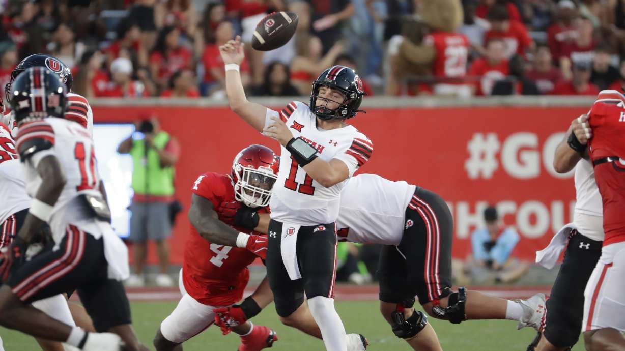 Utah quarterback Isaac Wilson (11) fumbles his pass attempt as Houston defender Brandon Mack (4) reaches from behind during the first half of an NCAA college football game Saturday, Oct. 26, 2024, in Houston.