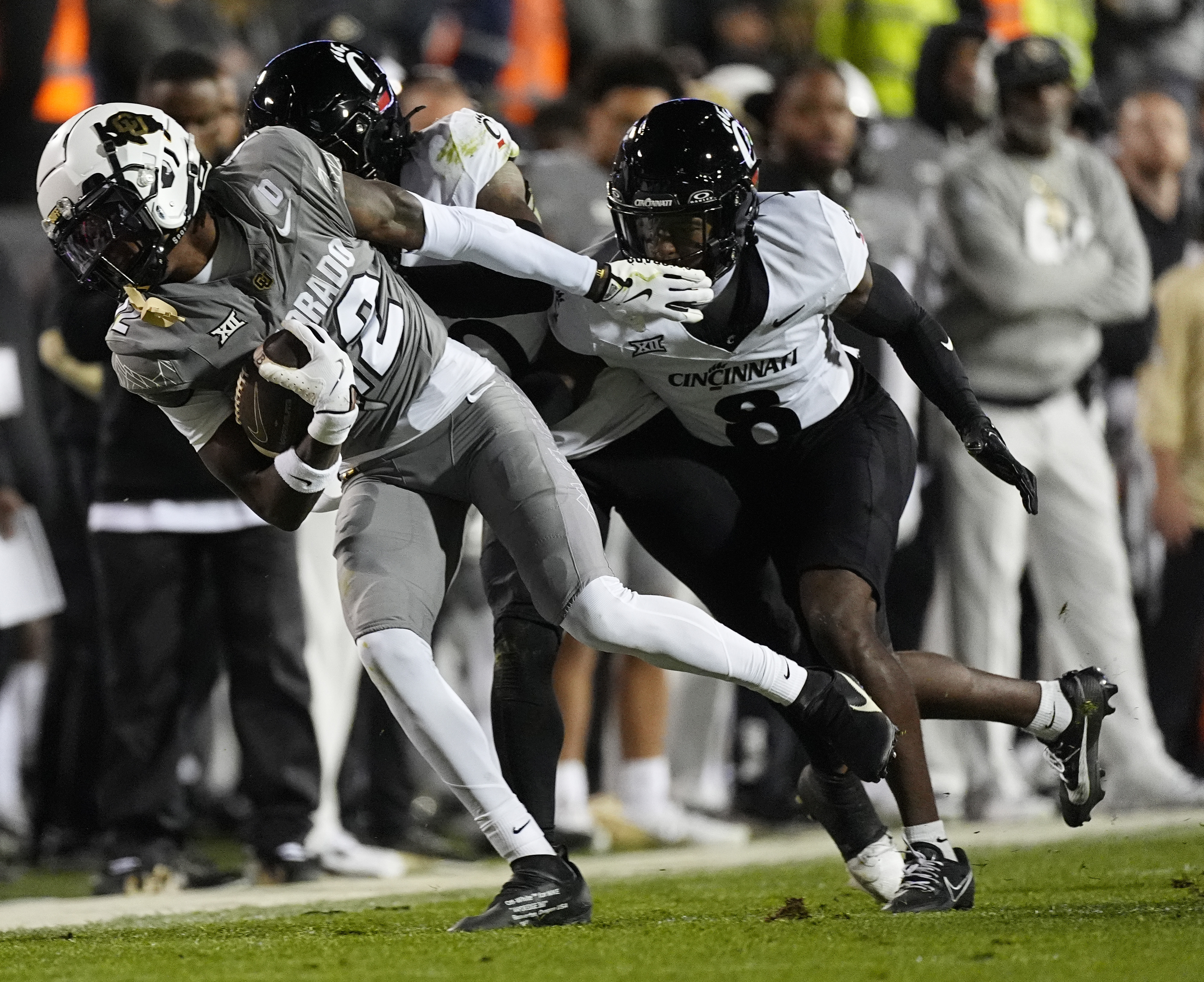 Colorado wide receiver Travis Hunter, front, is tackled by Cincinnati defensive back Derrick Canteen and cornerback Ormanie Arnold in the first half of an NCAA college football game Saturday, Oct. 26, 2024, in Boulder, Colo.