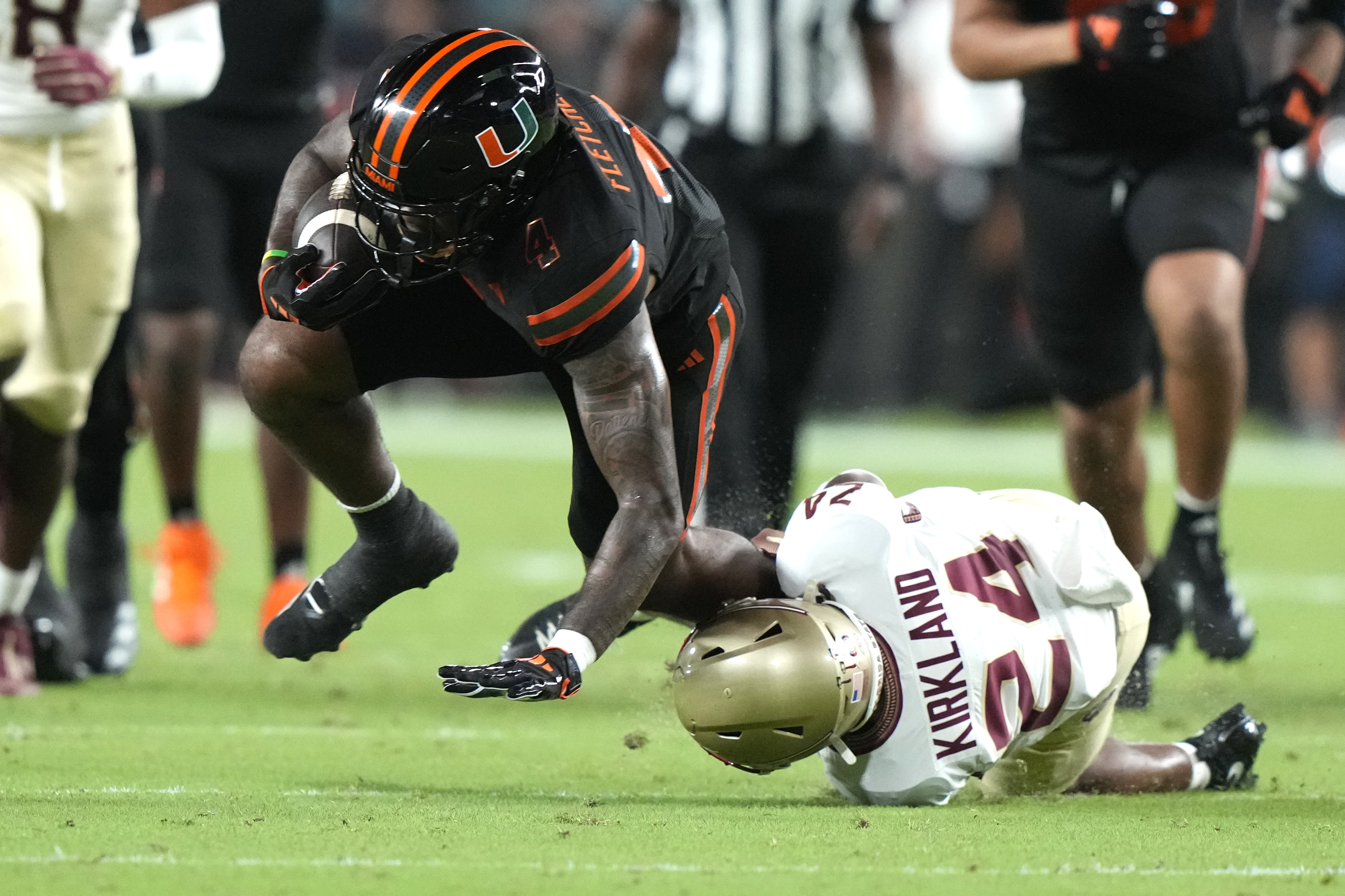 Miami running back Mark Fletcher Jr., left, runs for a first down as Florida State defensive back K.J. Kirkland (24) defends during the first half of an NCAA college football game, Saturday, Oct. 26, 2024, in Miami Gardens, Fla.