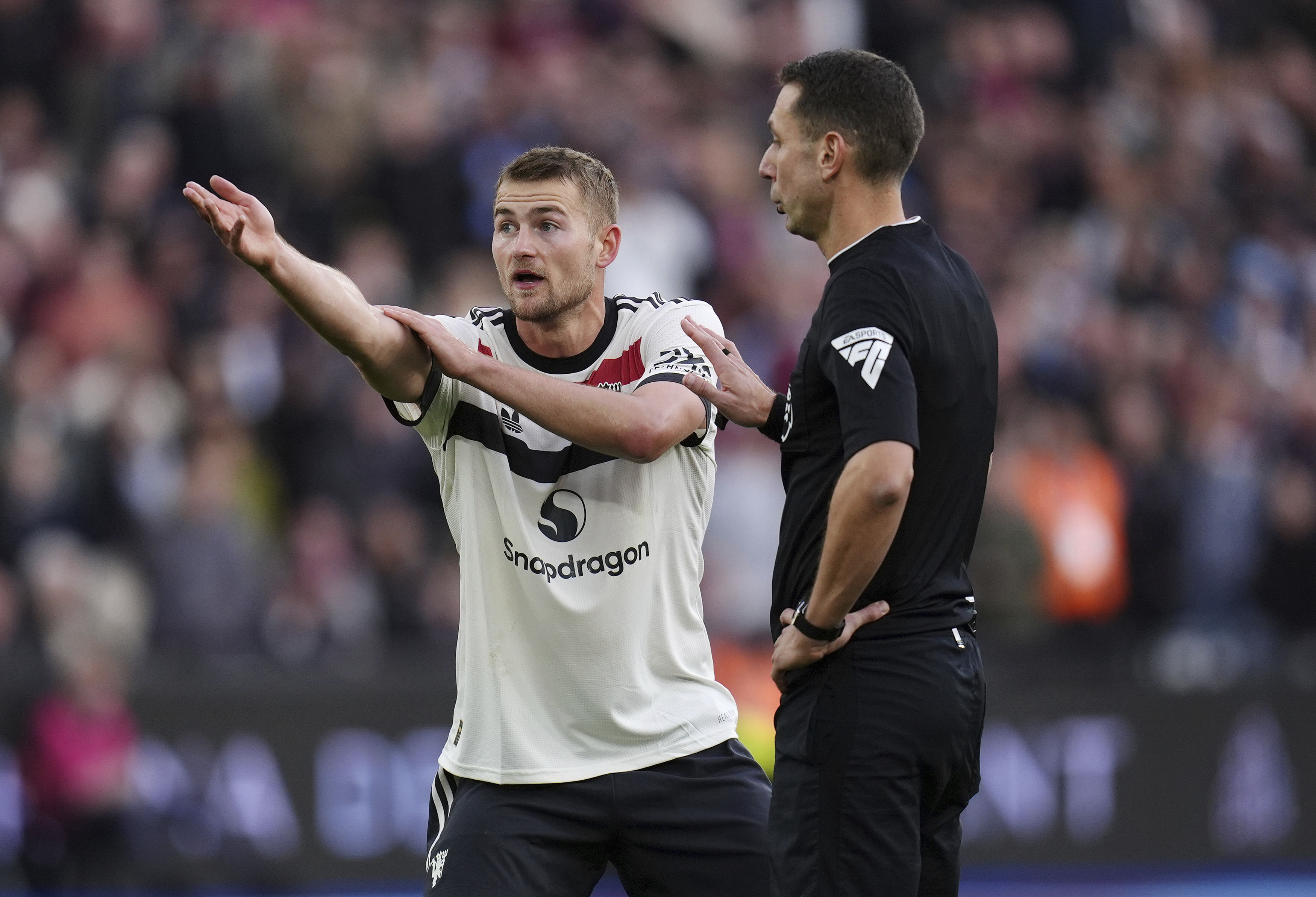 Manchester United's Matthijs de Ligt (left) protests to referee David Coote after he awards a penalty to West Ham United during the English Premier League soccer match between West Ham United and Manchester United at the London Stadium in London, Sunday, Oct. 27, 2024.