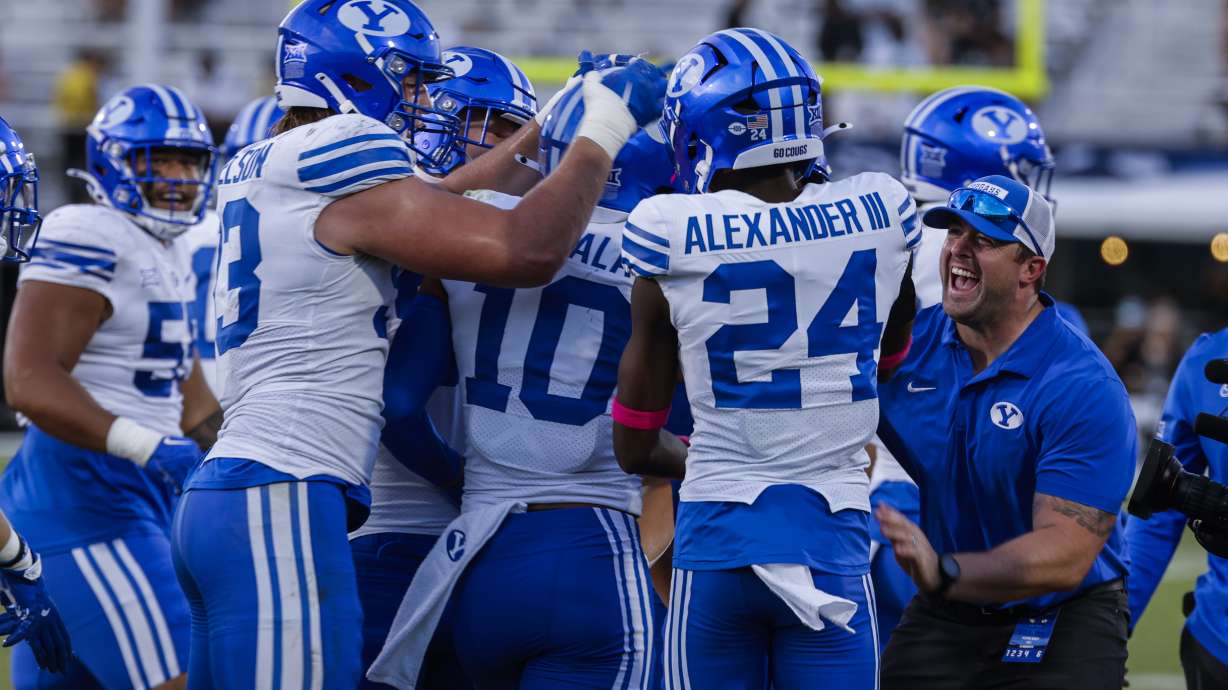 BYU safety Faletau Satuala (10) is swarmed by teammates after interception against Central Florida during the second half of an NCAA college football game, Saturday, Oct. 26, 2024, in Orlando, Fla.