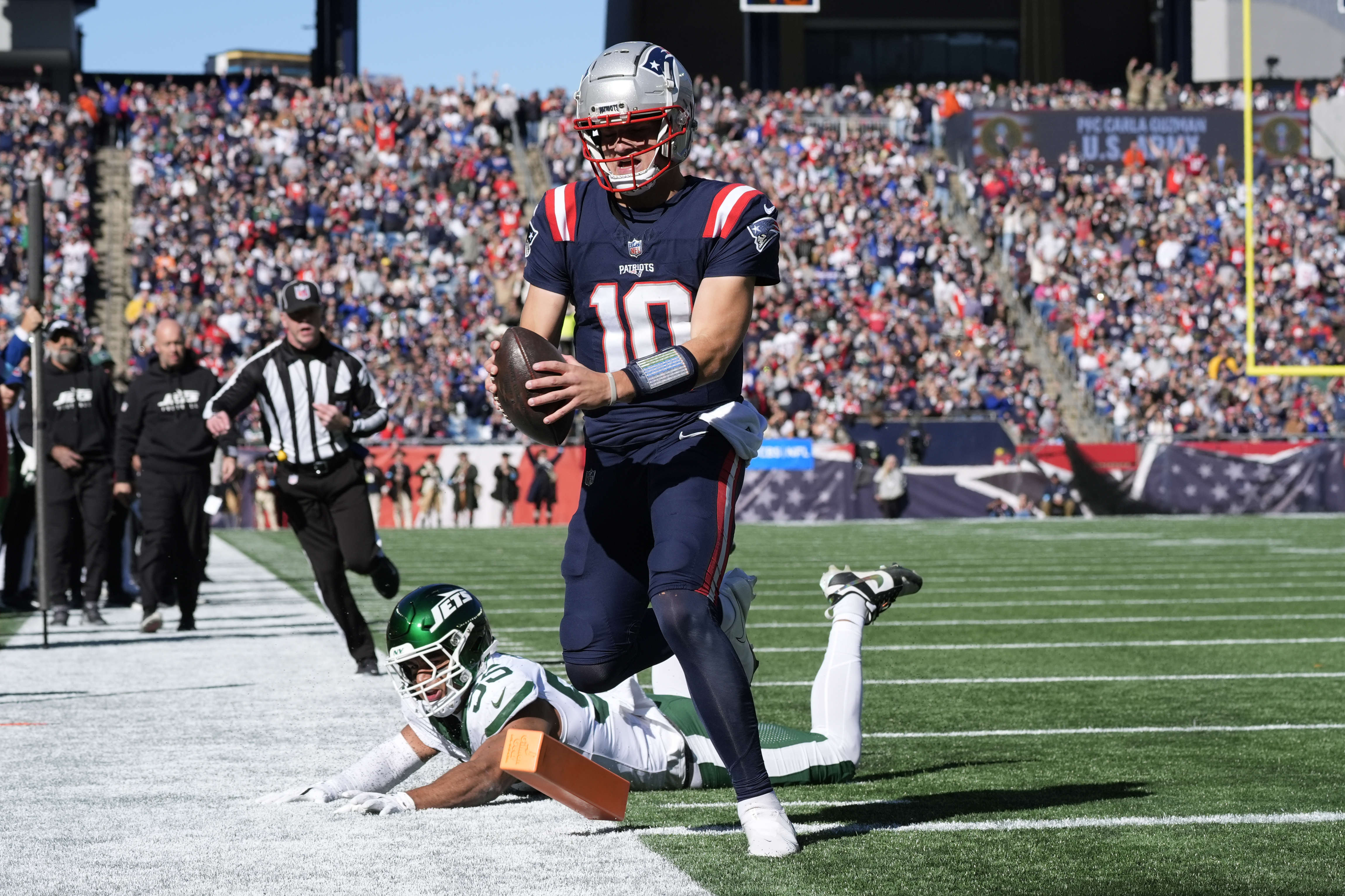 New England Patriots quarterback Drake Maye (10) runs into the end zone for a touchdown in front of New York Jets linebacker Chazz Surratt (55) in the first half of an NFL football game, Sunday, Oct. 27, 2024, in Foxborough, Mass. 