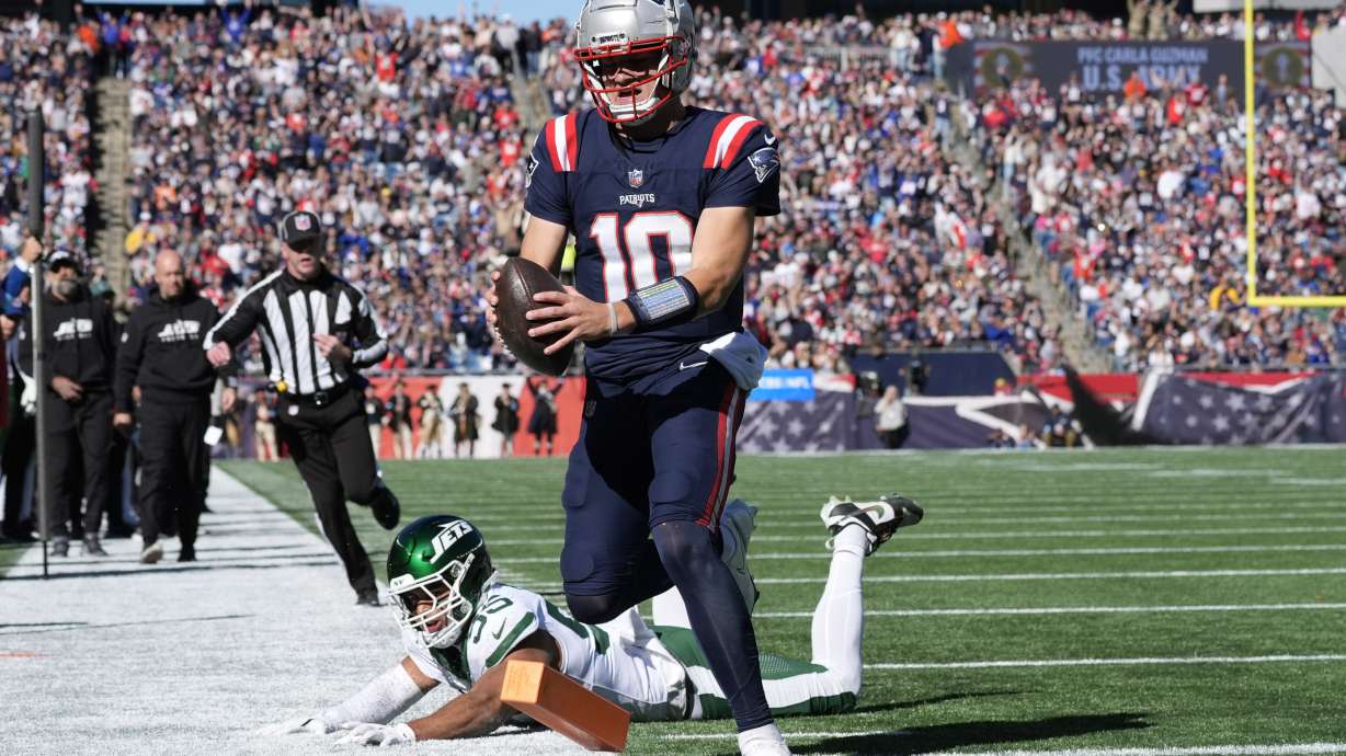 New England Patriots quarterback Drake Maye (10) runs into the end zone for a touchdown in front of New York Jets linebacker Chazz Surratt (55) in the first half of an NFL football game, Sunday, Oct. 27, 2024, in Foxborough, Mass.