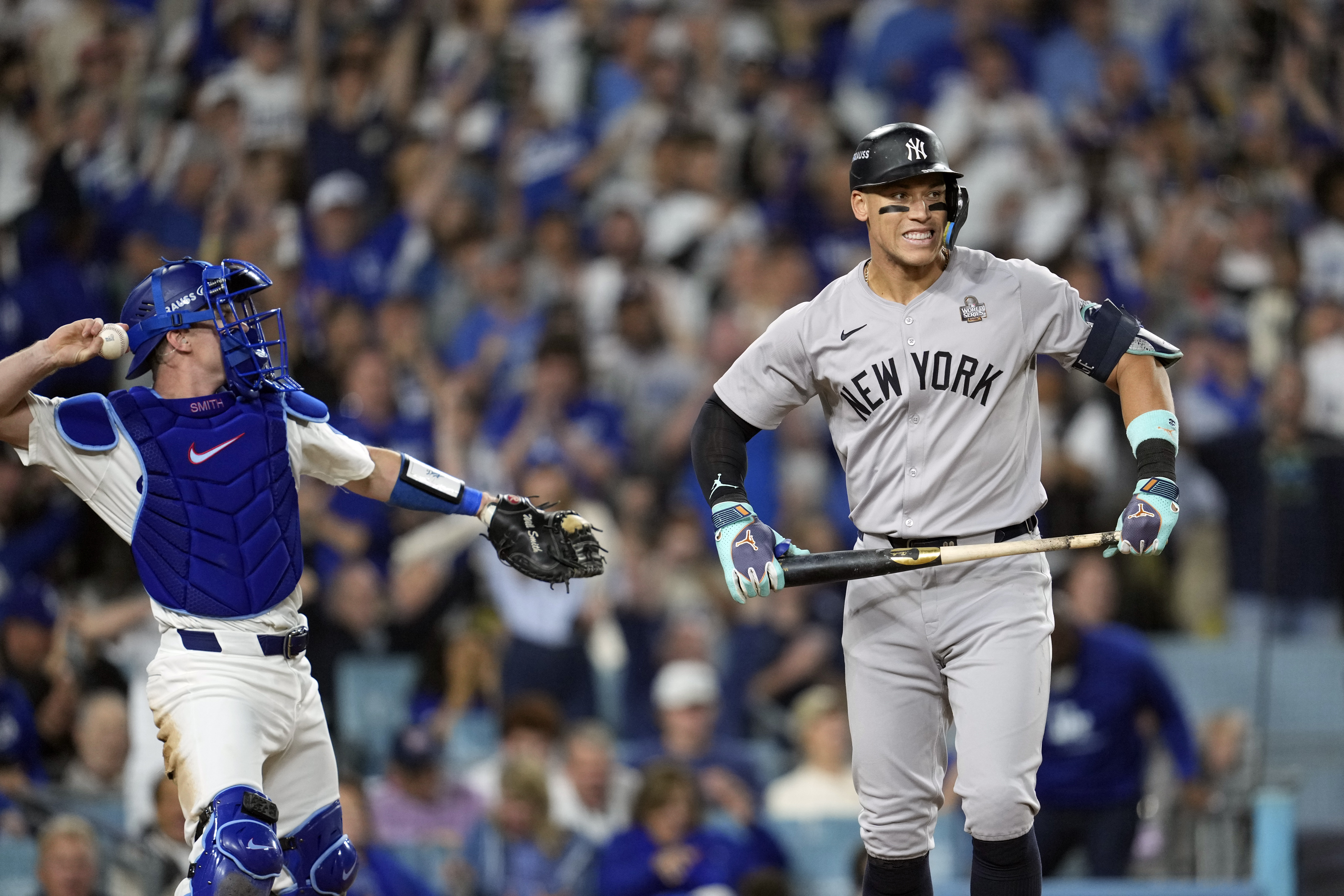 New York Yankees' Aaron Judge, right, reacts after striking out as Los Angeles Dodgers catcher Will Smith throws the ball around the infield during the sixth inning in Game 2 of the baseball World Series, Saturday, Oct. 26, 2024, in Los Angeles.