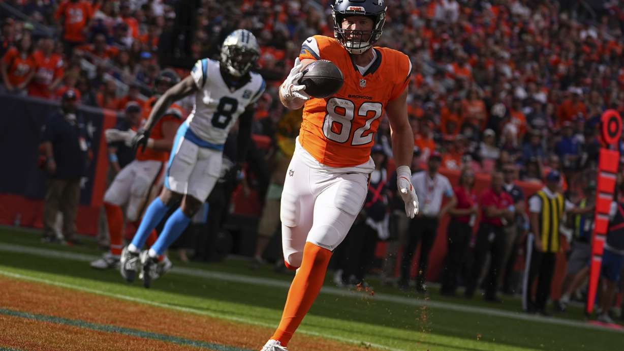 Denver Broncos tight end Adam Trautman (82) catches a pass for a touchdown against the Carolina Panthers during the first half of an NFL football game Sunday, Oct. 27, 2024, in Denver.