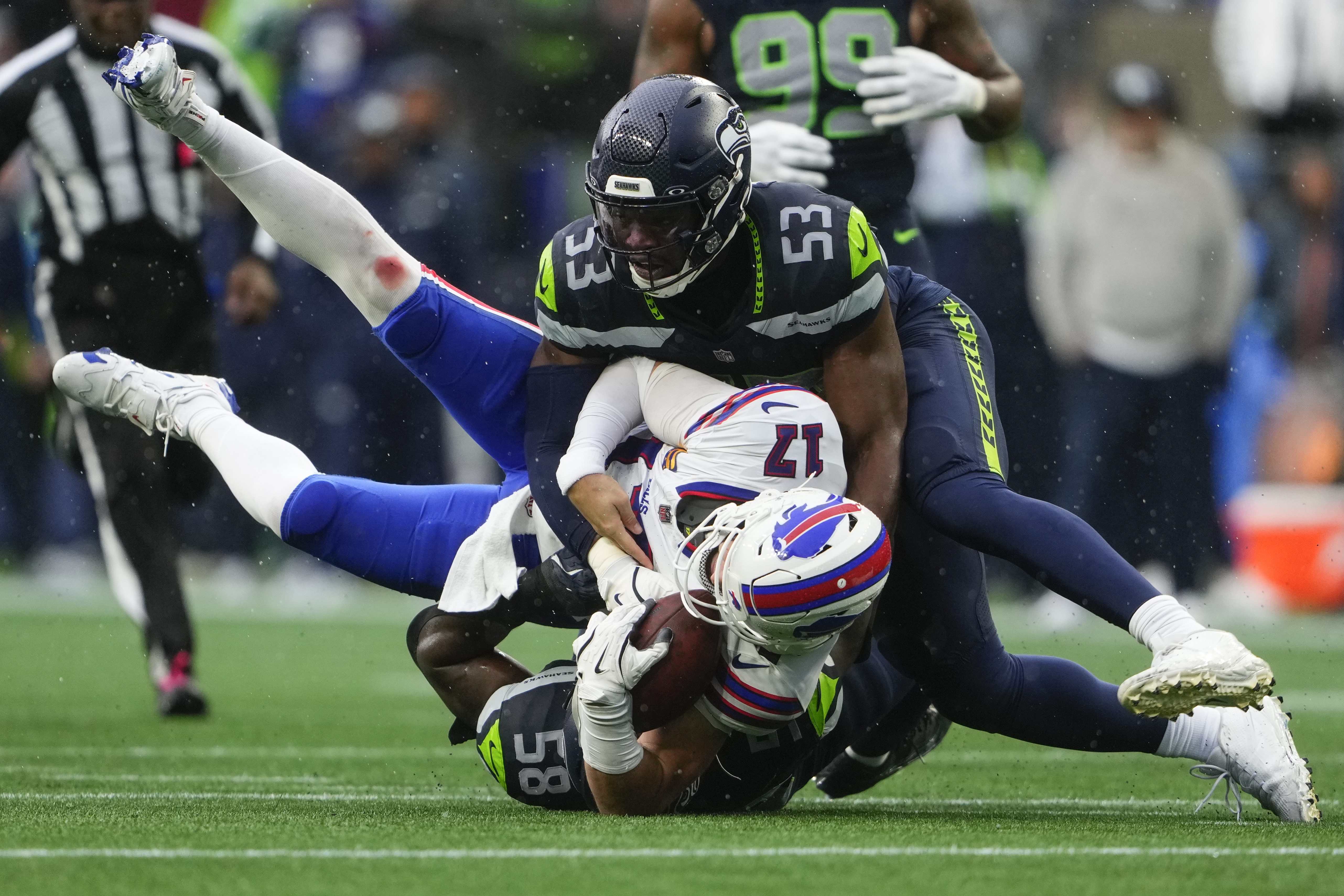 Buffalo Bills quarterback Josh Allen (17) is tackled by Seattle Seahawks linebacker Boye Mafe (53) and linebacker Derick Hall (58) during the first half of an NFL football game, Sunday, Oct. 27, 2024, in Seattle. 