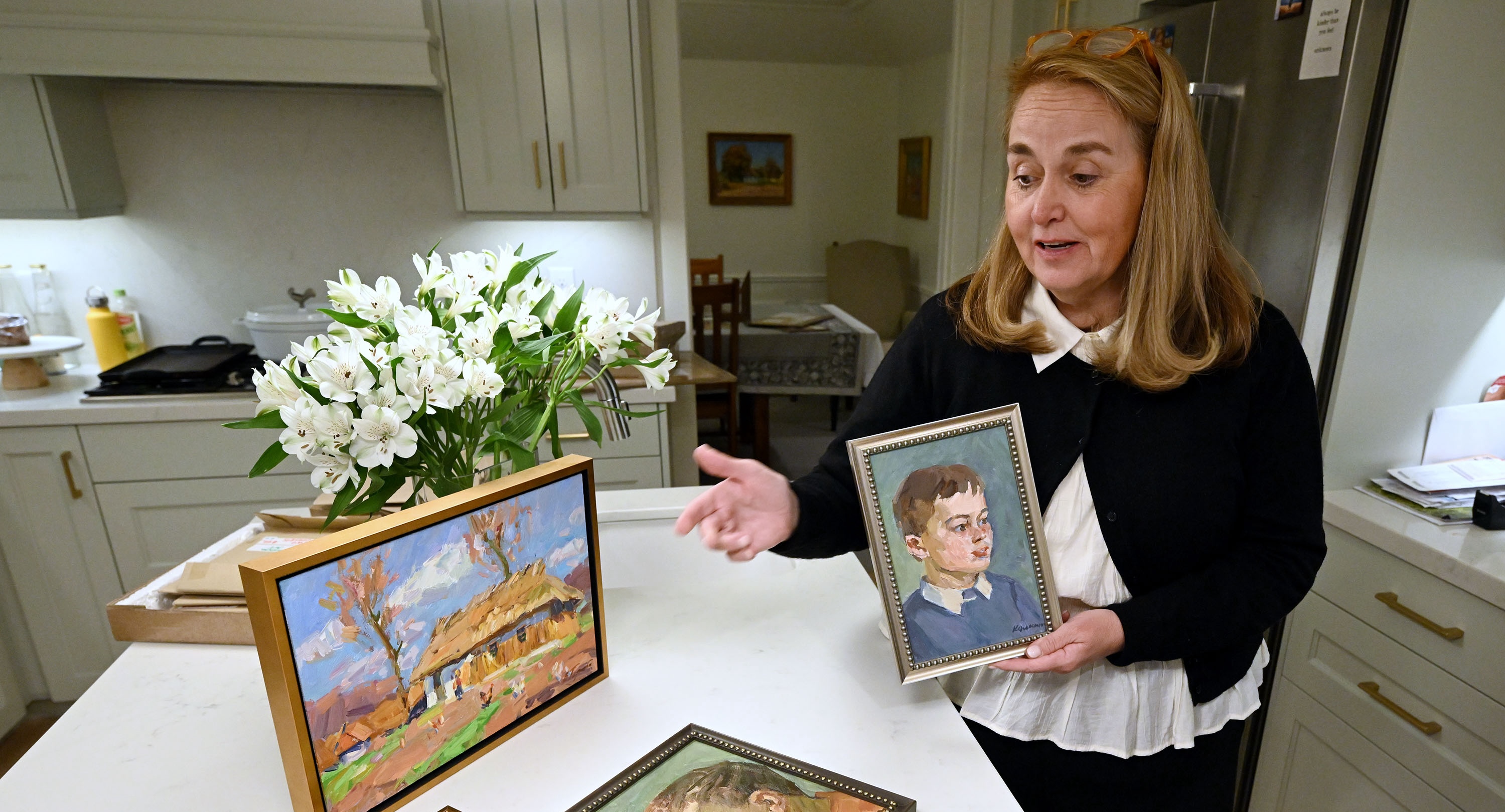 Mary Milliner talks about paintings by artists V.A. Kolesnik and Vyacheslav as she and her sisters Marta Dansie and Sarah Dansie talk about their work to import art from Ukraine to raise money for the war effort at Mary’s Holladay home on Sept. 17.