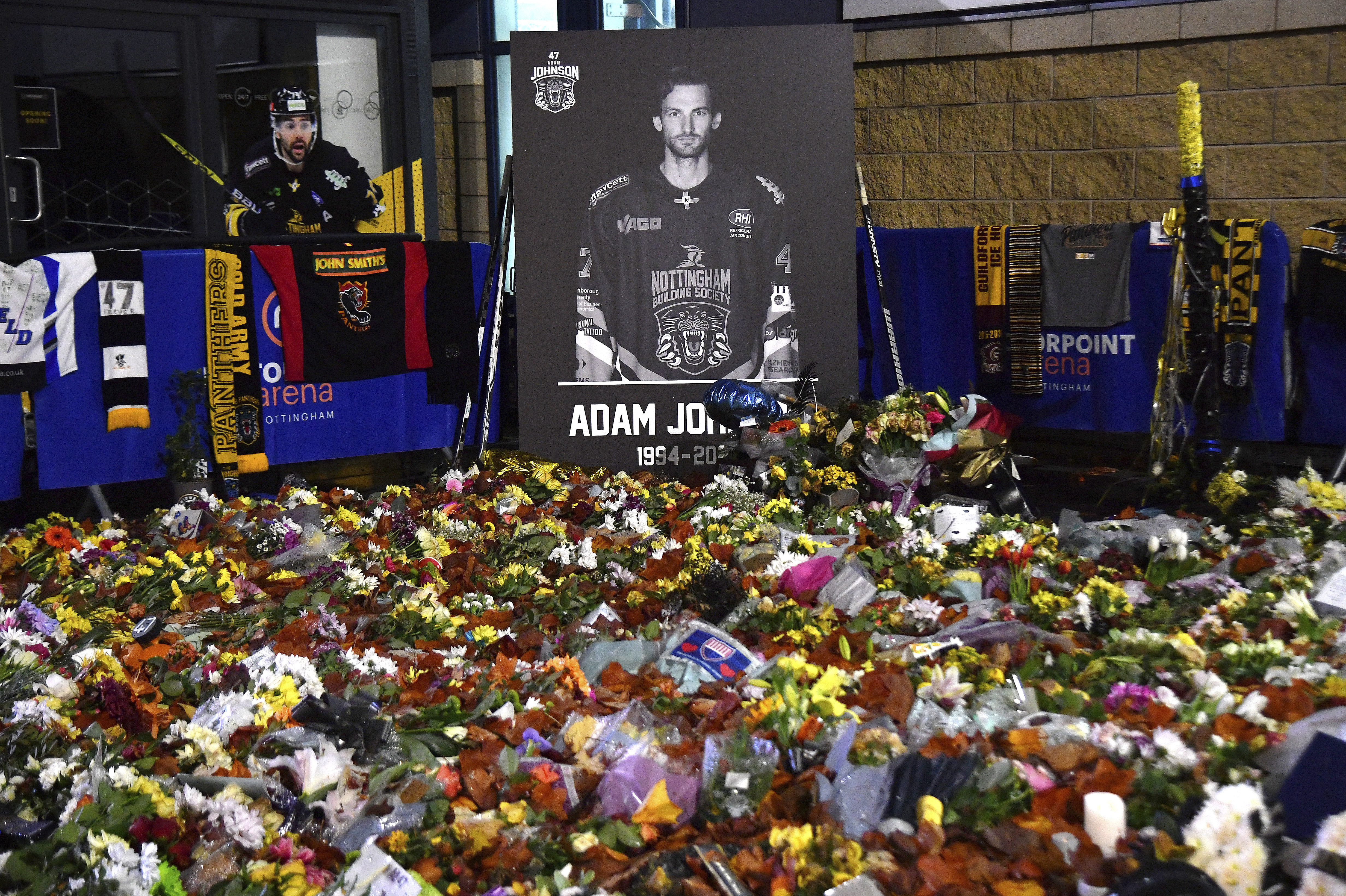 FILE - Flower tributes for Nottingham Panthers player Adam Johnson rest outside the Motorpoint Arena before a memorial ice hockey game between Nottingham Panthers and Manchester Storm in Nottingham, England, Nov. 18, 2023. 