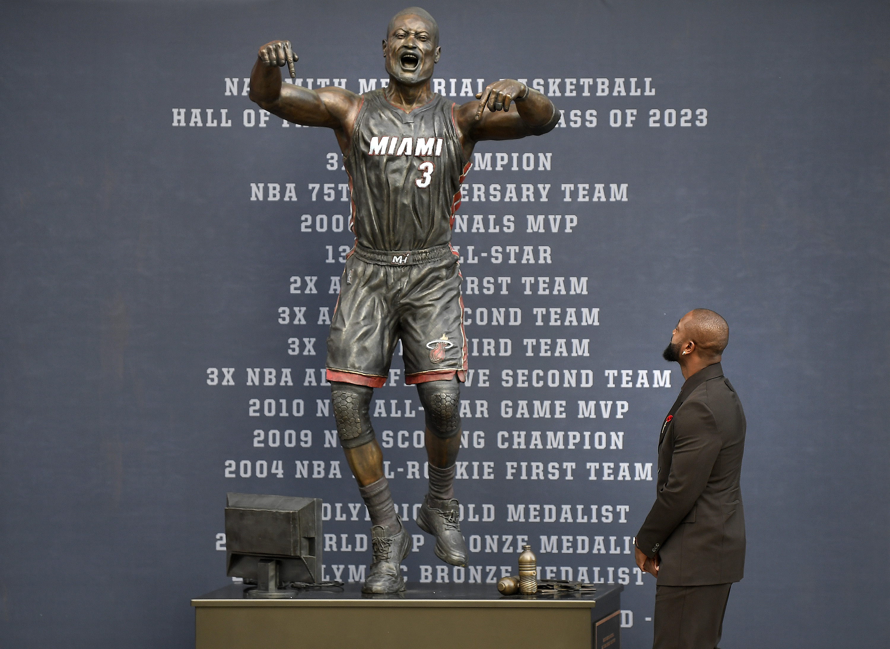 Former Miami Heat NBA basketball player Dwyane Wade looks at a bronze statue in his image during its unveiling ceremony outside Kaseya Center, Sunday, Oct. 27, 2024, in Miami, Fla.