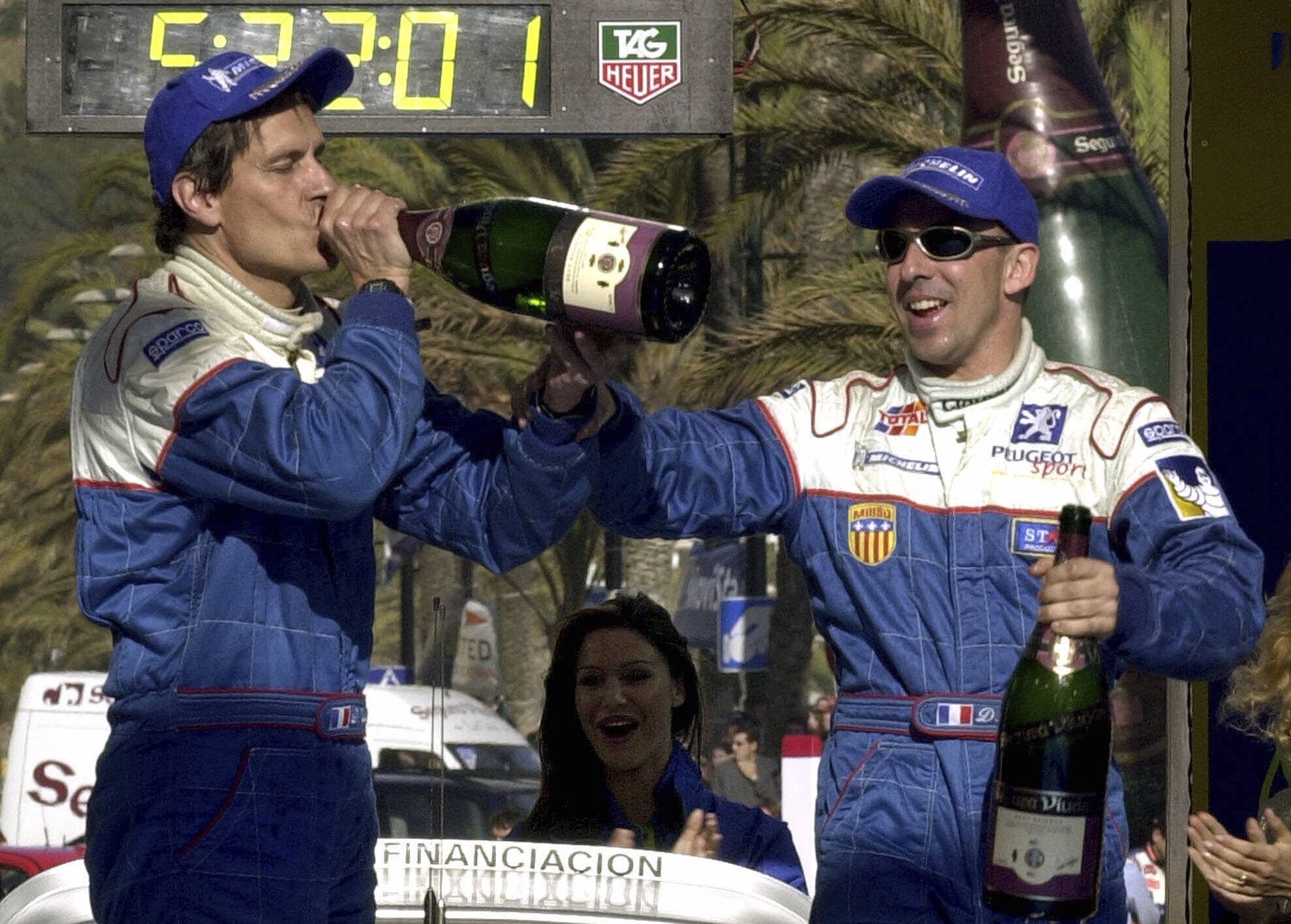 FILE - France's Didier Auriol, right, and his co-driver Denis Giraudet, of the Peugeot Team, celebrates from the winner's podium after winning the Catalonian rally, north eastern Spain, Sunday, March 25, 2001. 