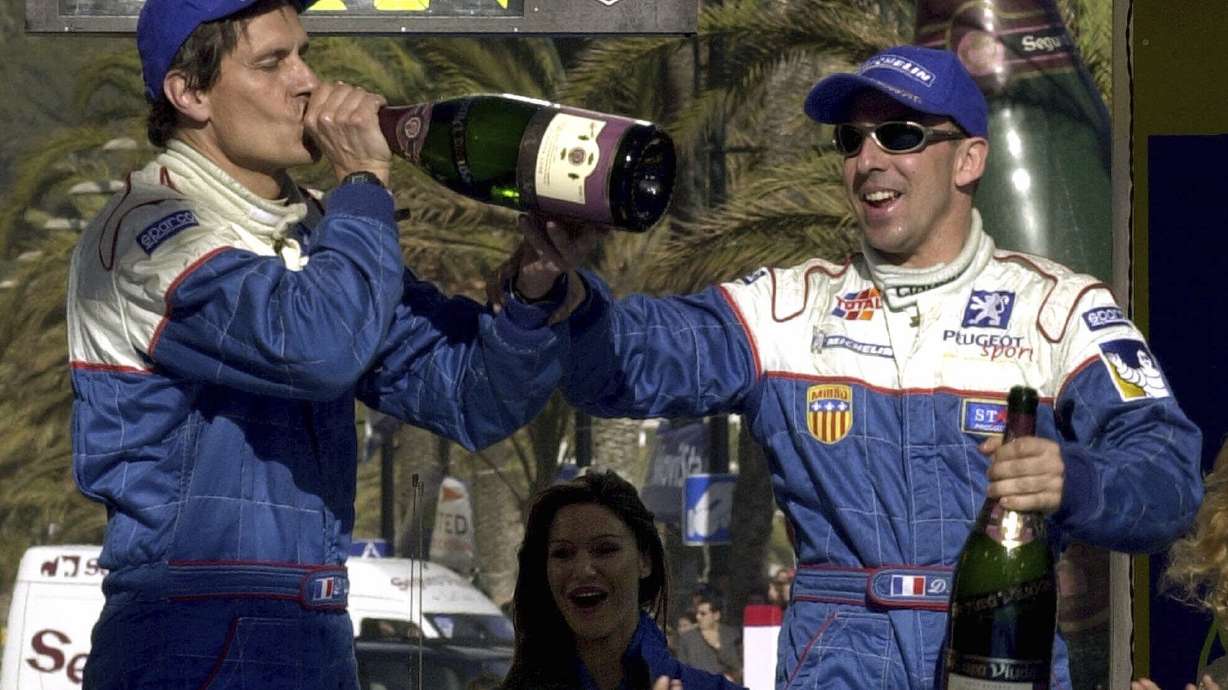 FILE - France's Didier Auriol, right, and his co-driver Denis Giraudet, of the Peugeot Team, celebrates from the winner's podium after winning the Catalonian rally, north eastern Spain, Sunday, March 25, 2001.