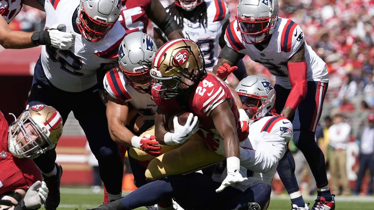 New England Patriots linebacker Joshua Uche, bottom middle right, and teammates tackle San Francisco 49ers running back Jordan Mason (24) during the first half of an NFL football game in Santa Clara, Calif., Sunday, Sept. 29, 2024.