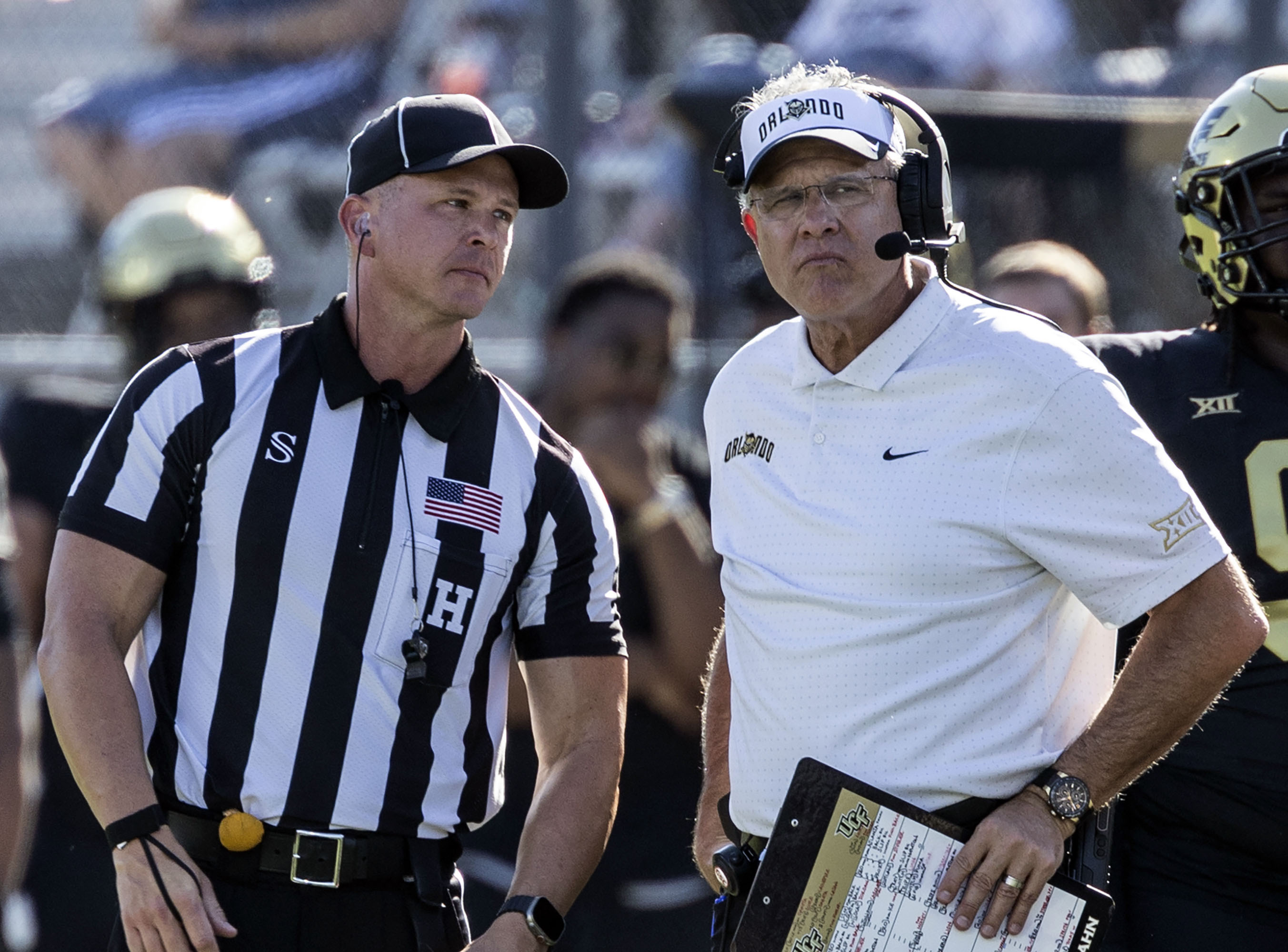 Central Florida head coach Gus Malzahn, right, stands next to a referee, left, while a play is reviewed during the first half of an NCAA college football game against BYU, Saturday, Oct. 26, 2024, in Orlando, Fla. 