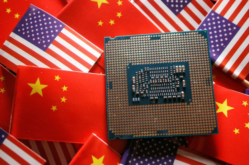 A central processing unit semiconductor chip is displayed among flags of China and the U.S. The Biden administration said on Monday it is finalizing rules that will limit U.S. investments in artificial intelligence in China.