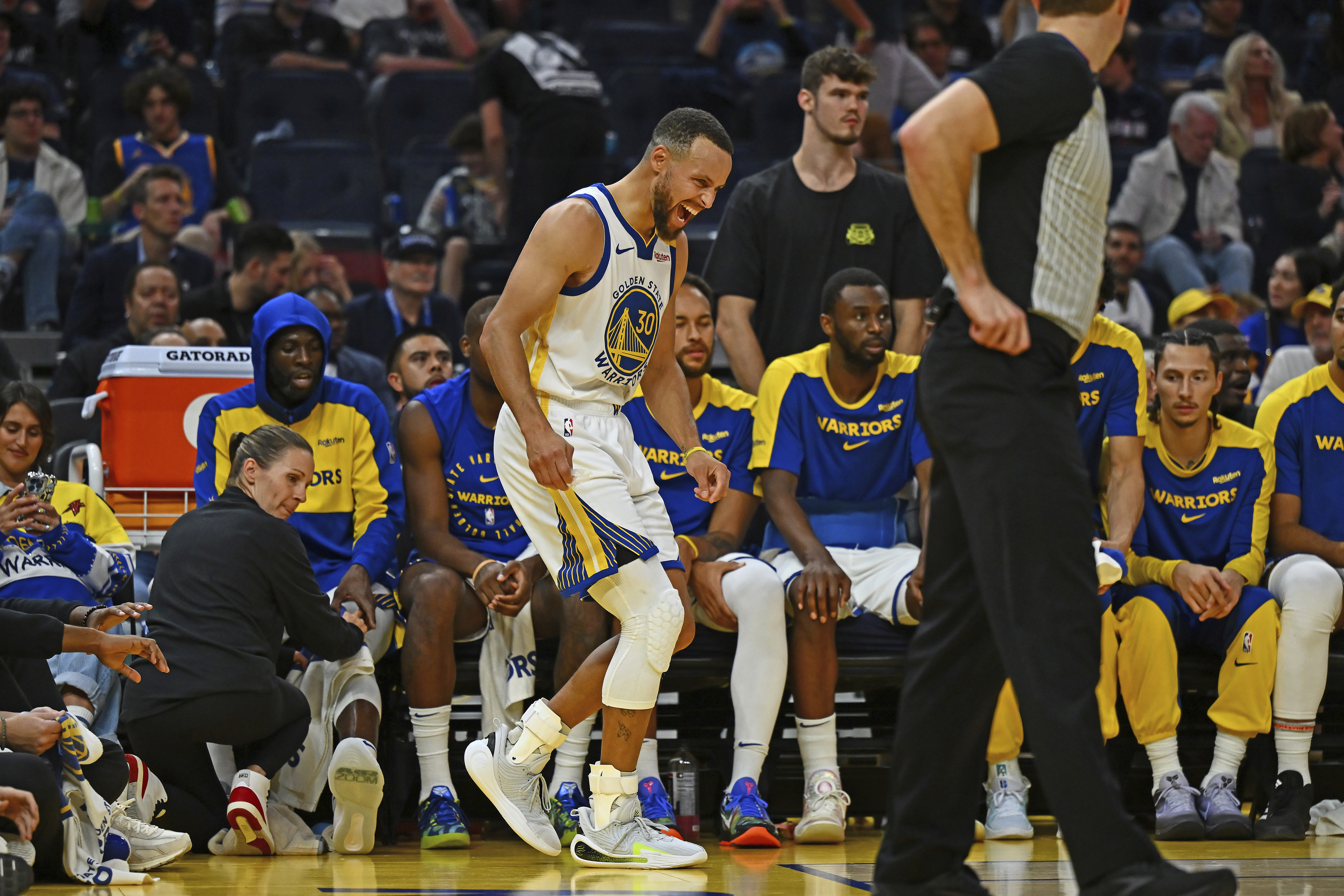 Golden State Warriors' Stephen Curry, center, yells after sustaining an injury to his left ankle in the fourth quarter of an NBA basketball game against the Los Angeles Clippers in San Francisco, Sunday, Oct. 27, 2024.