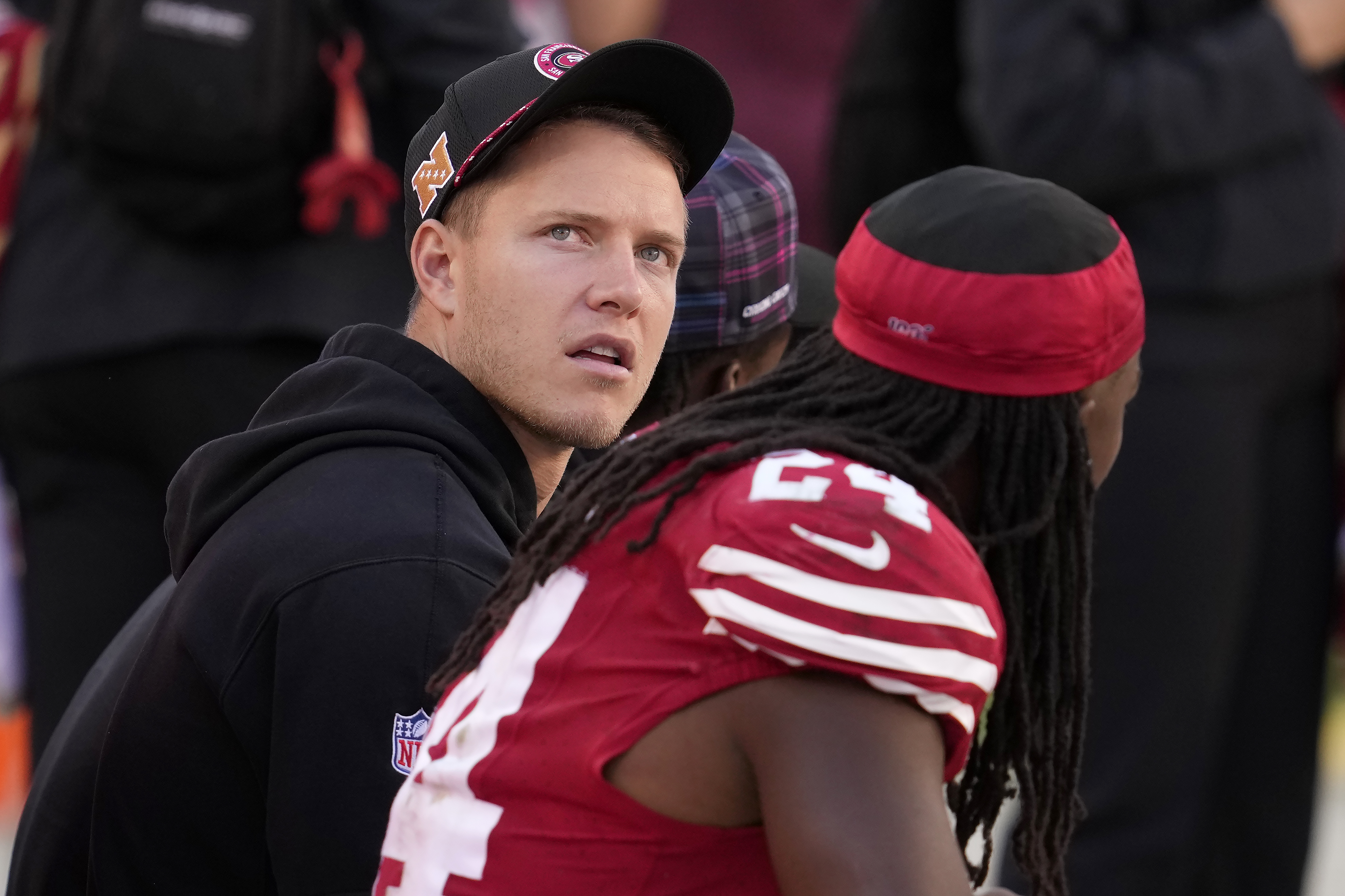 San Francisco 49ers running back Christian McCaffrey, left, sits on the sideline next to running back Jordan Mason during the second half of an NFL football game against the New England Patriots in Santa Clara, Calif., Sunday, Sept. 29, 2024. 