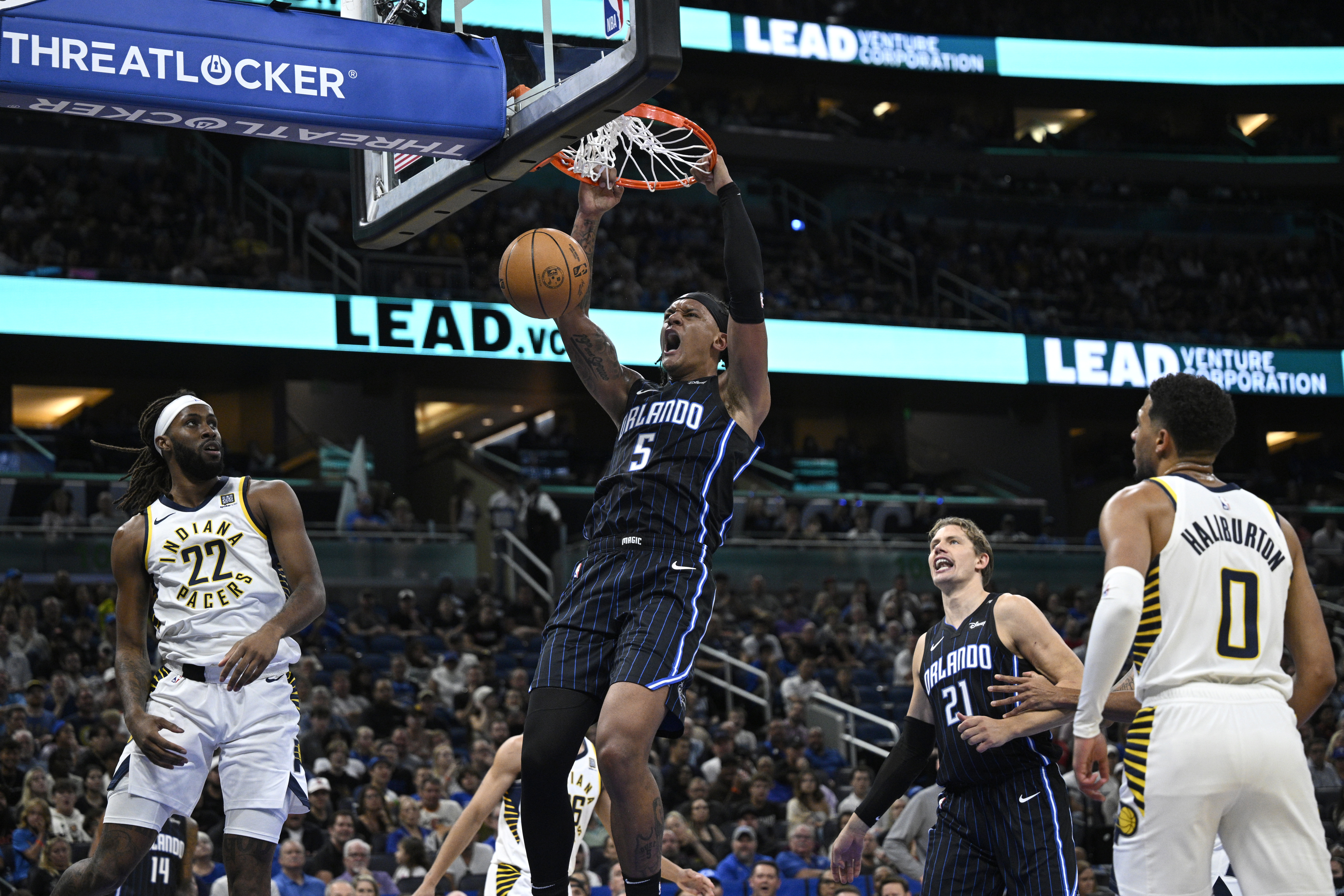 Orlando Magic forward Paolo Banchero (5) dunks between Indiana Pacers forward Isaiah Jackson (22) and guard Tyrese Haliburton (0) during the first half of an NBA basketball game, Monday, Oct. 28, 2024, in Orlando, Fla.