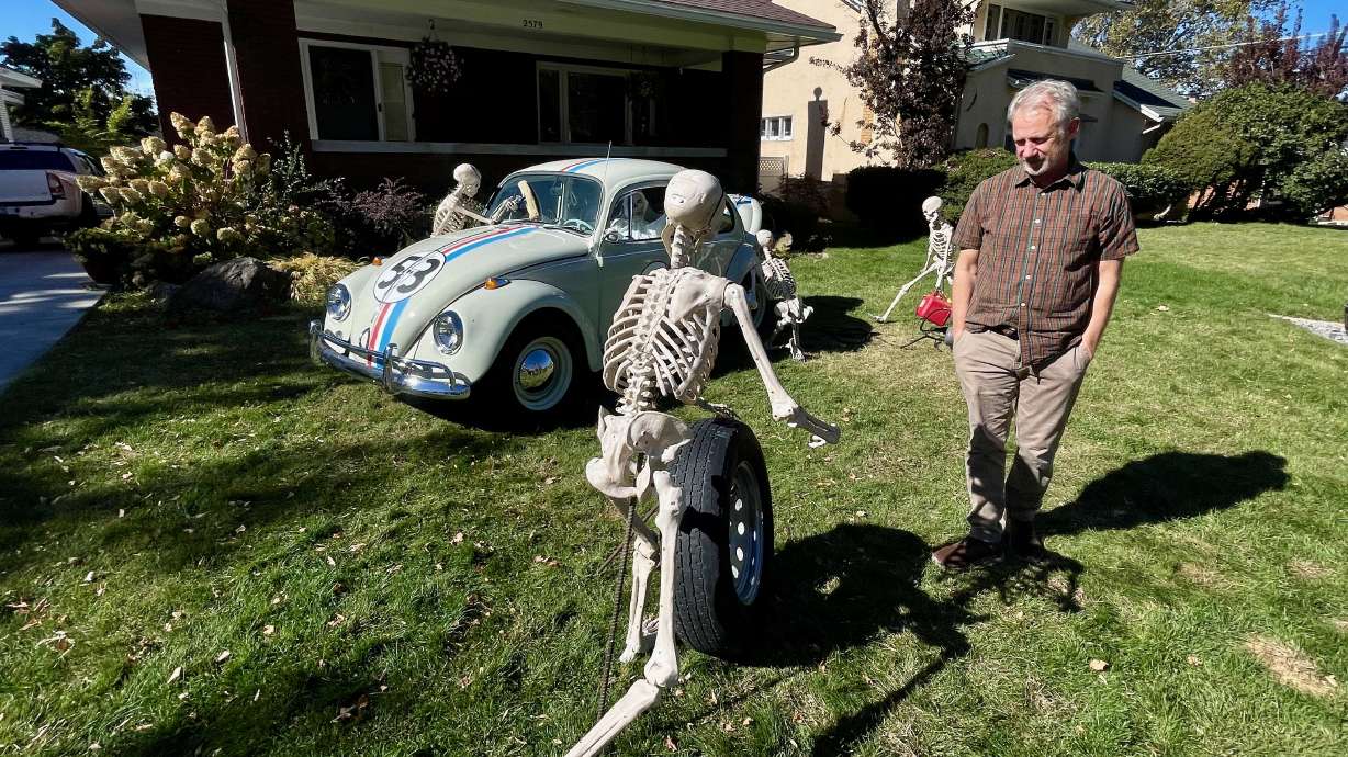 Ron Pippin, on Oct. 23, watches a crew of skeletons attend to Herbie the Love Bug — one of the rotating Halloween displays he puts up outside his Ogden home each October.