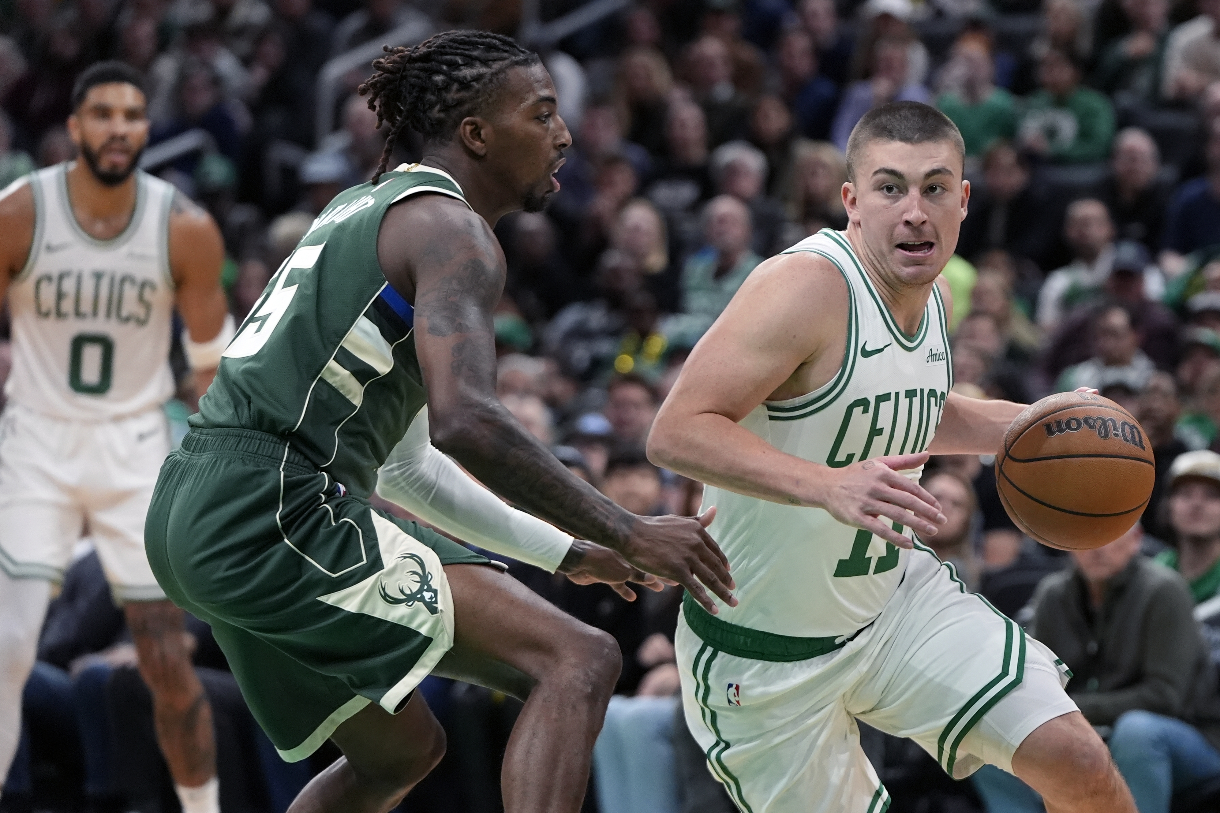 Boston Celtics' Payton Pritchard (11) drives past Milwaukee Bucks' Delon Wright, front left, during the first half of an NBA basketball game, Monday, Oct. 28, 2024, in Boston.