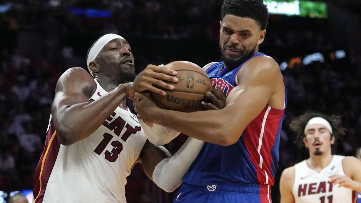 Miami Heat center Bam Adebayo (13) and Detroit Pistons forward Tobias Harris, front right, fight for control of the ball during the first half of an NBA basketball game, Monday, Oct. 28, 2024, in Miami.