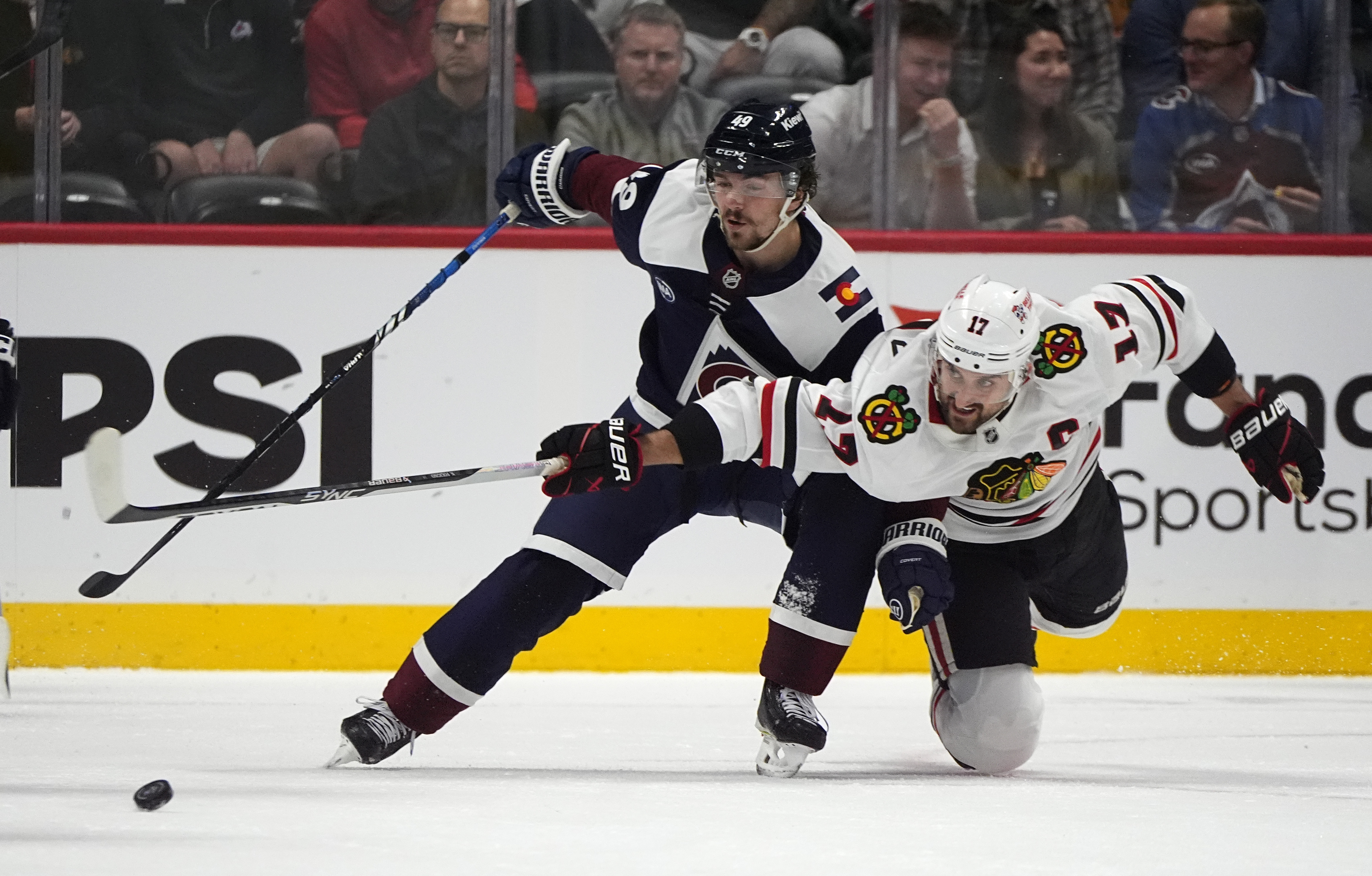 Colorado Avalanche defenseman Samuel Girard, left, gets tangled up with Chicago Blackhawks left wing Nick Foligno in the first period of an NHL hockey game Monday, Oct. 28, 2024, in Denver. 