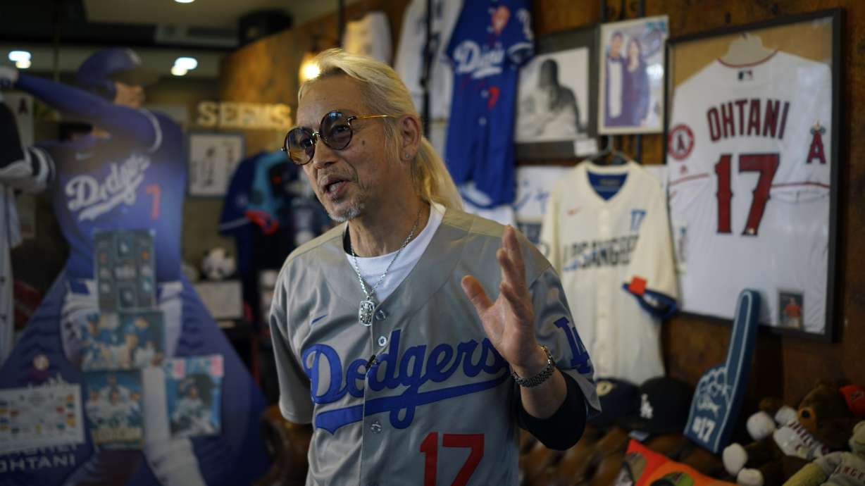 Hironobu Kanno, representative of a private fan club of Shohei Ohtani of the Los Angeles Dodgers, speaks surrounded by his collection goods of Ohtani at his beauty salon in Oshu, northeastern Japan, the hometown of Ohtani, Tuesday, Oct. 29, 2024.