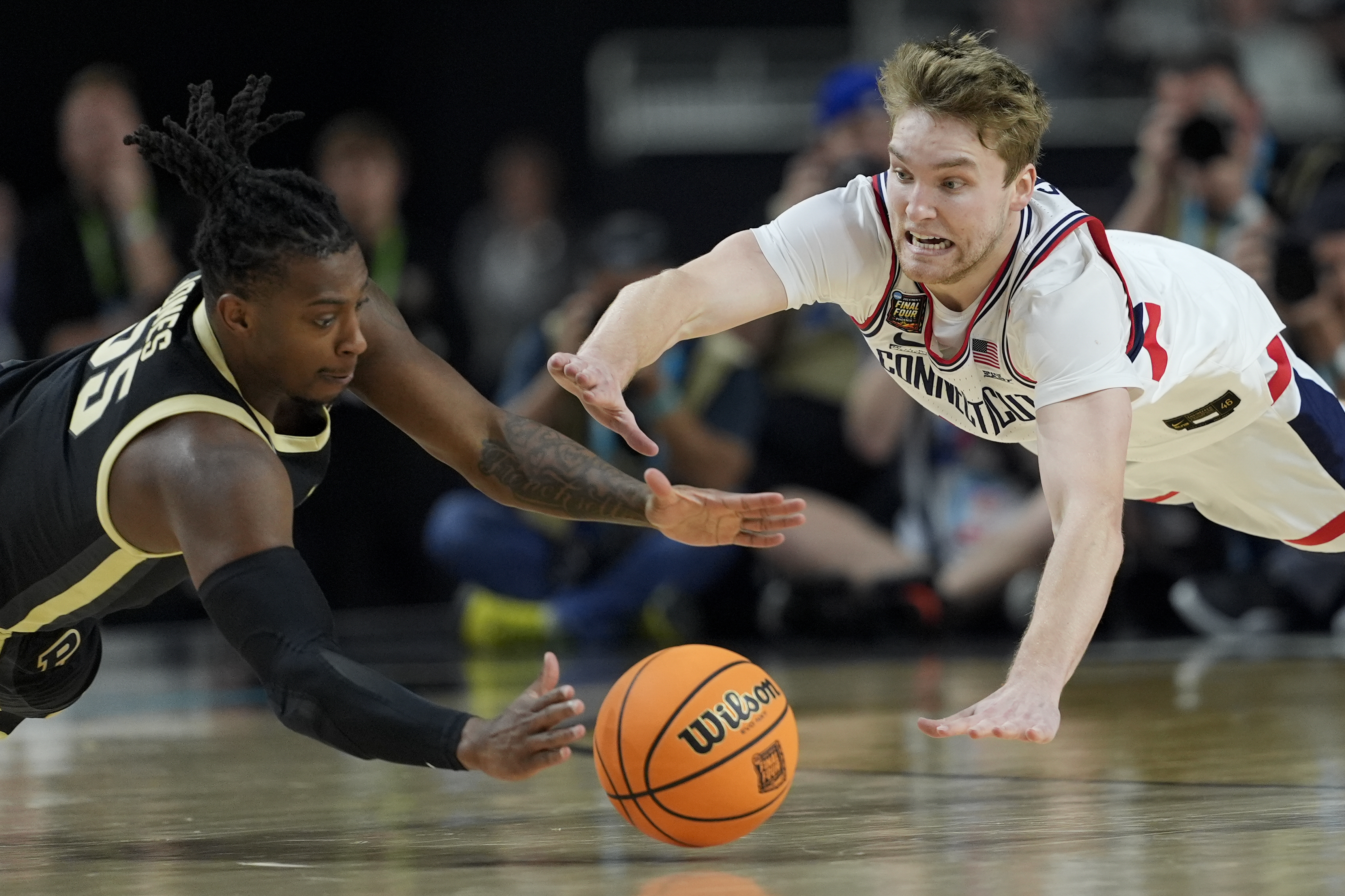 FILE - Purdue guard Lance Jones (55) vies for the ball with UConn guard Cam Spencer (12) during the second half of the NCAA college Final Four championship basketball game, Monday, April 8, 2024, in Glendale, Ariz. 