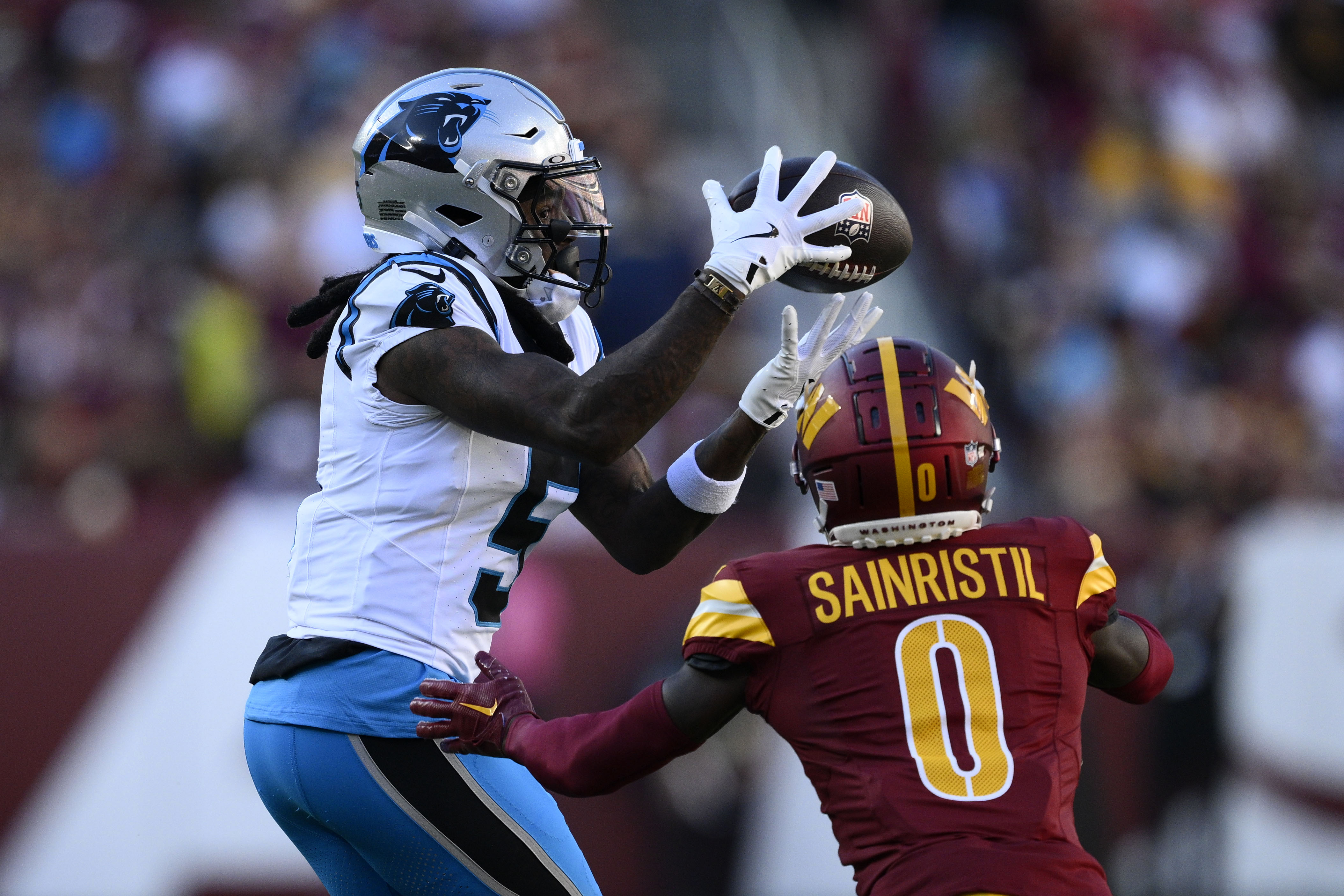 Carolina Panthers wide receiver Diontae Johnson (5) catches a pass over Washington Commanders cornerback Mike Sainristil (0) during the first half of an NFL football game, Sunday, Oct. 20, 2024, in Landover, Md. 