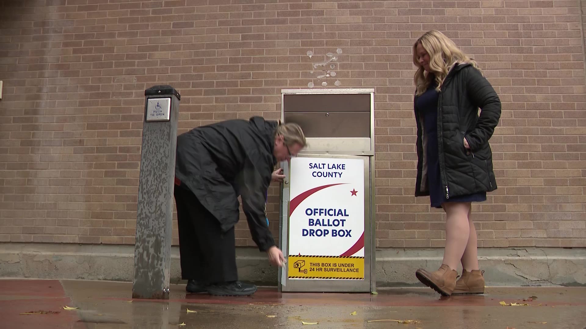 Salt Lake County Clerk Lannie Chapman and a Salt Lake County election worker open up a drop box to showcase the safeguards in place on Tuesday.