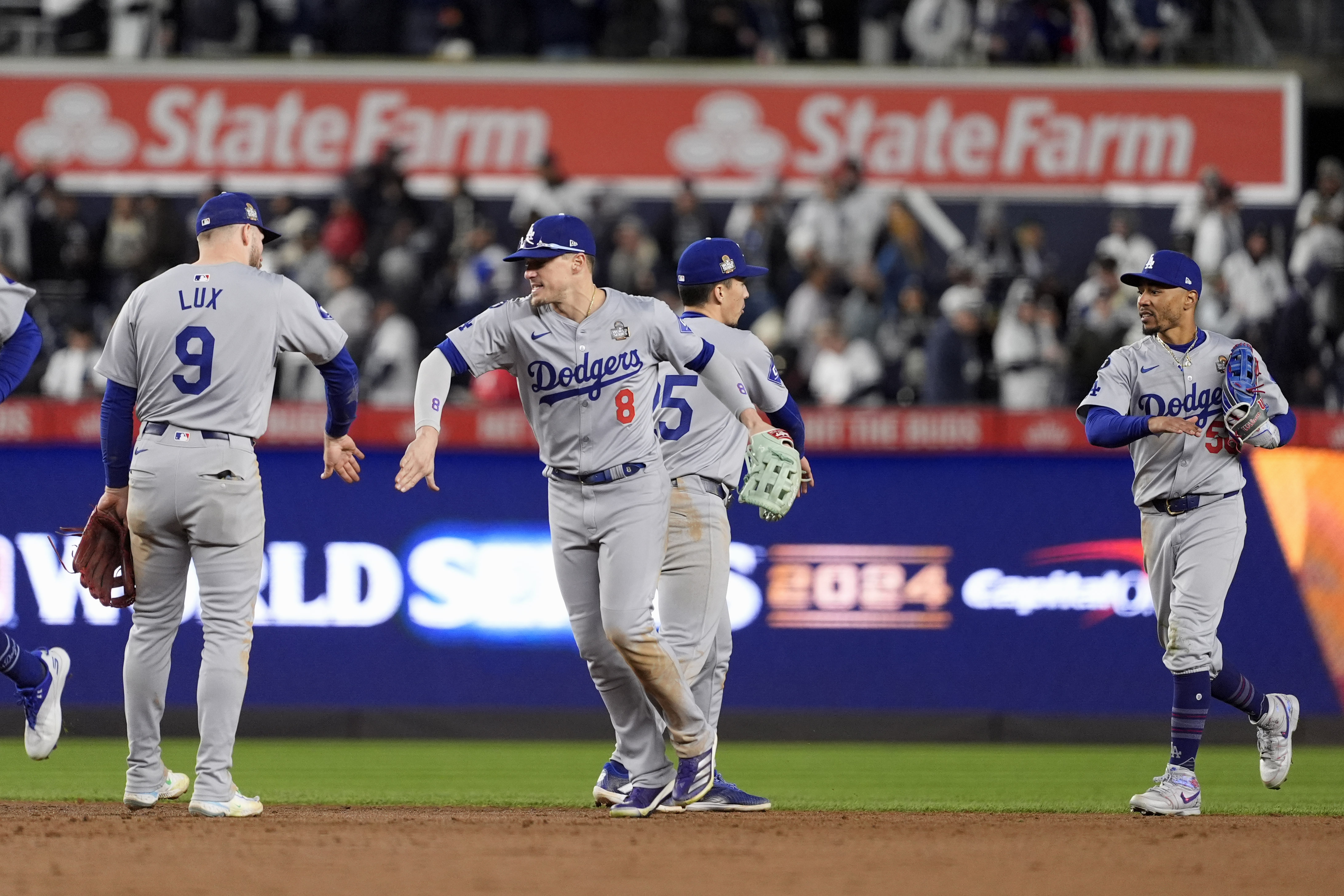 Los Angeles Dodgers' Gavin Lux (9), Kiké Hernández (8), Tommy Edman (25) and Mookie Betts (50) celebrate after Game 3 of the baseball World Series against the New York Yankees, Monday, Oct. 28, 2024, in New York. The Dodgers won 4-2. 