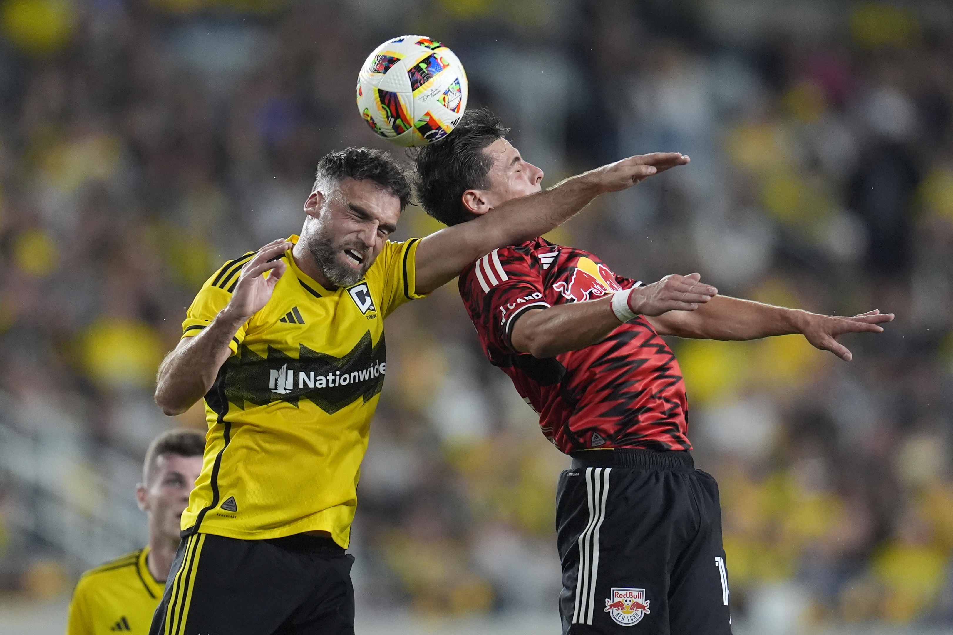 Columbus Crew defender Rudy Camacho, left, and New York Red Bulls forward Dante Vanzeir, right, head the ball in the first half of a first-round soccer match of the MLS Cup playoffs, Tuesday, Oct. 29, 2024, in Columbus, Ohio.