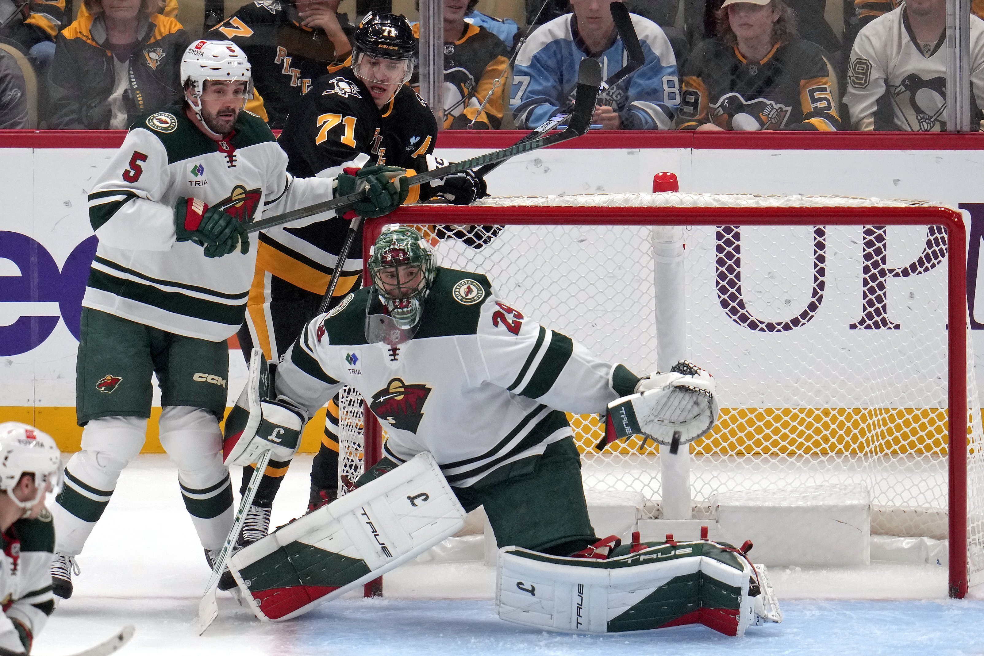 Pittsburgh Penguins' Rickard Rakell gets a shot past Minnesota Wild goaltender Marc-Andre Fleury for a goal as Jake Middleton (5) defends Evgeni Malkin (71) during the first period of an NHL hockey game in Pittsburgh, Tuesday, Oct. 29, 2024. 