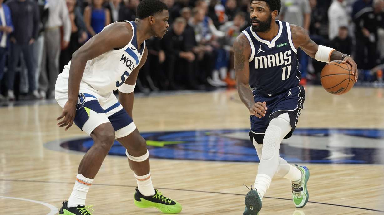 Dallas Mavericks guard Kyrie Irving (11) works toward the basket as Minnesota Timberwolves guard Anthony Edwards (5) defends during the first half of an NBA basketball game, Tuesday, Oct. 29, 2024, in Minneapolis.