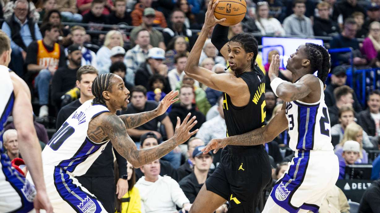 Utah Jazz forward Cody Williams (5) looks to drive the ball while gaurded by Sacramento Kings guard Keon Ellis (23) and forward DeMar DeRozan (10) during an NBA basketball game held at the Delta Center in Salt Lake City on Tuesday, Oct. 29, 2024.