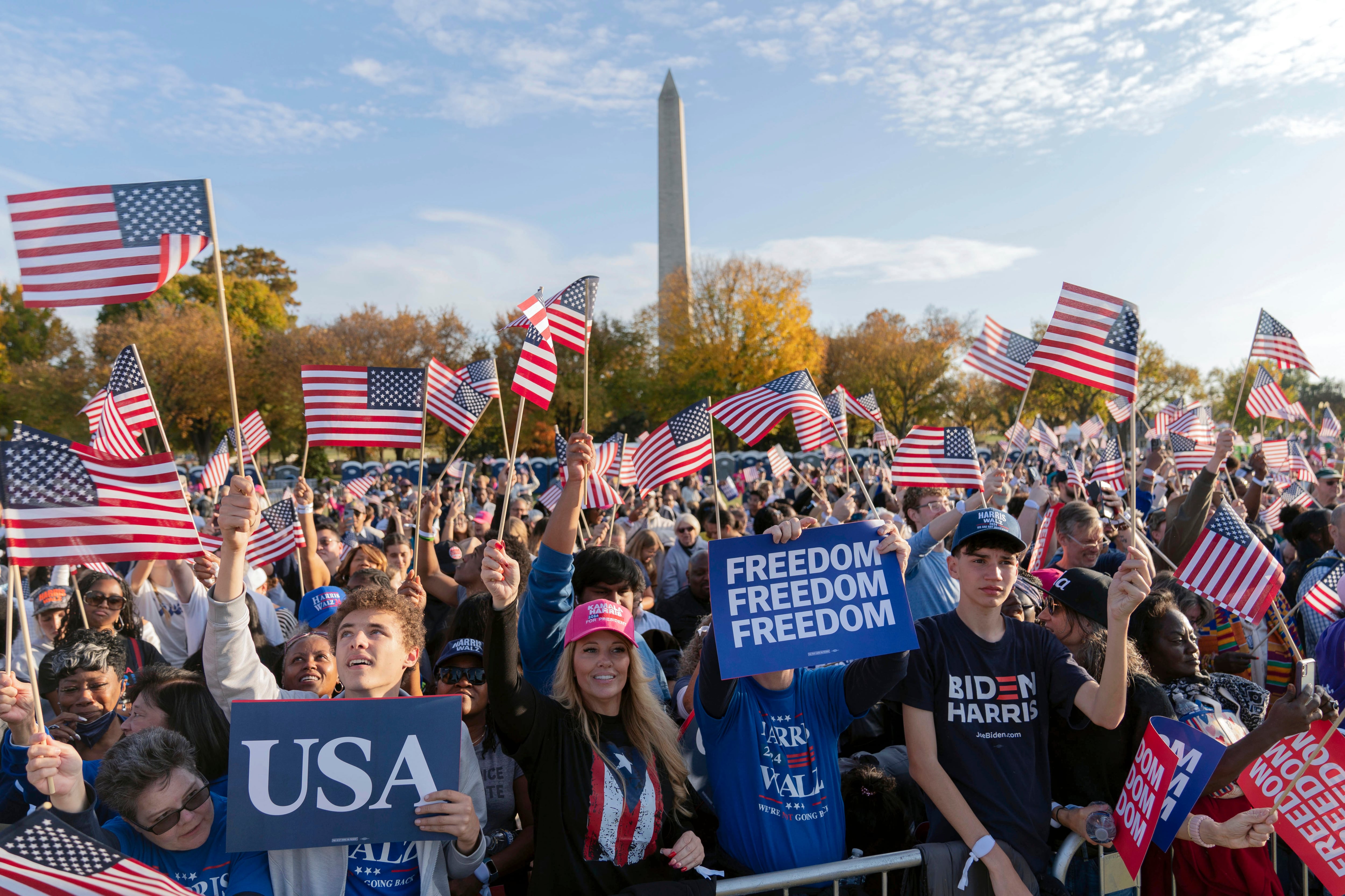 With the Washington Monument in the background, supporters of Democratic presidential nominee Vice President Kamala Harris wave American flags as they attend a campaign rally in Washington on Tuesday.