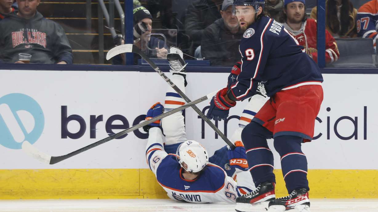 Columbus Blue Jackets' Ivan Provorov, right, knocks Edmonton Oilers' Connor McDavid to the ice during the first period of an NHL hockey game Monday, Oct. 28, 2024, in Columbus, Ohio.