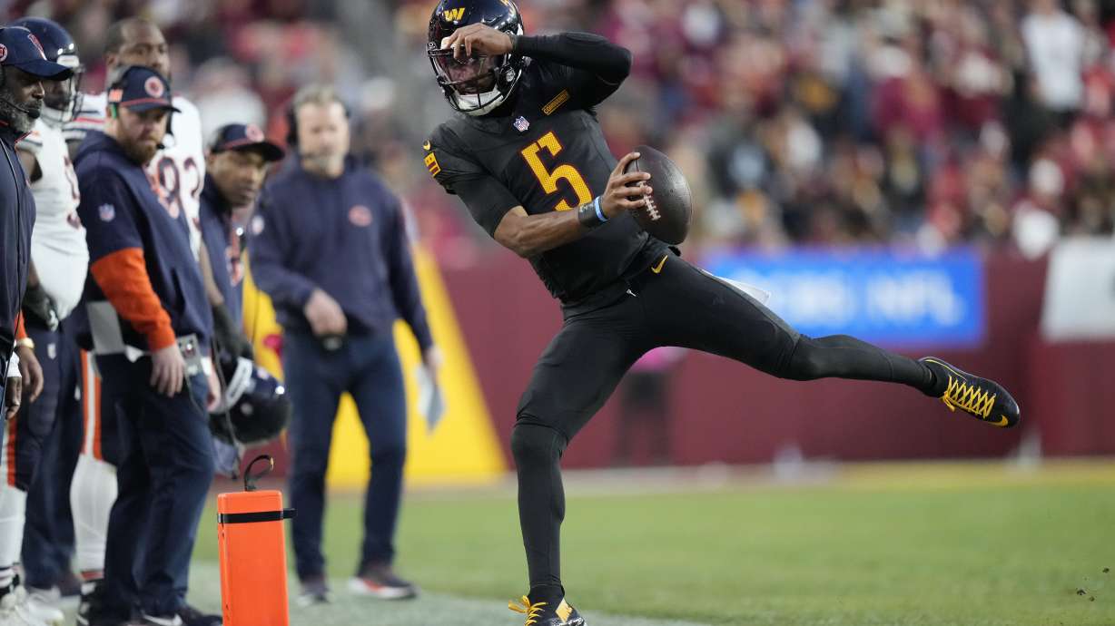 Washington Commanders quarterback Jayden Daniels (5) tries to stay in bounds in the second half of an NFL football game against the Chicago Bears Sunday, Oct. 27, 2024, in Landover, Md.