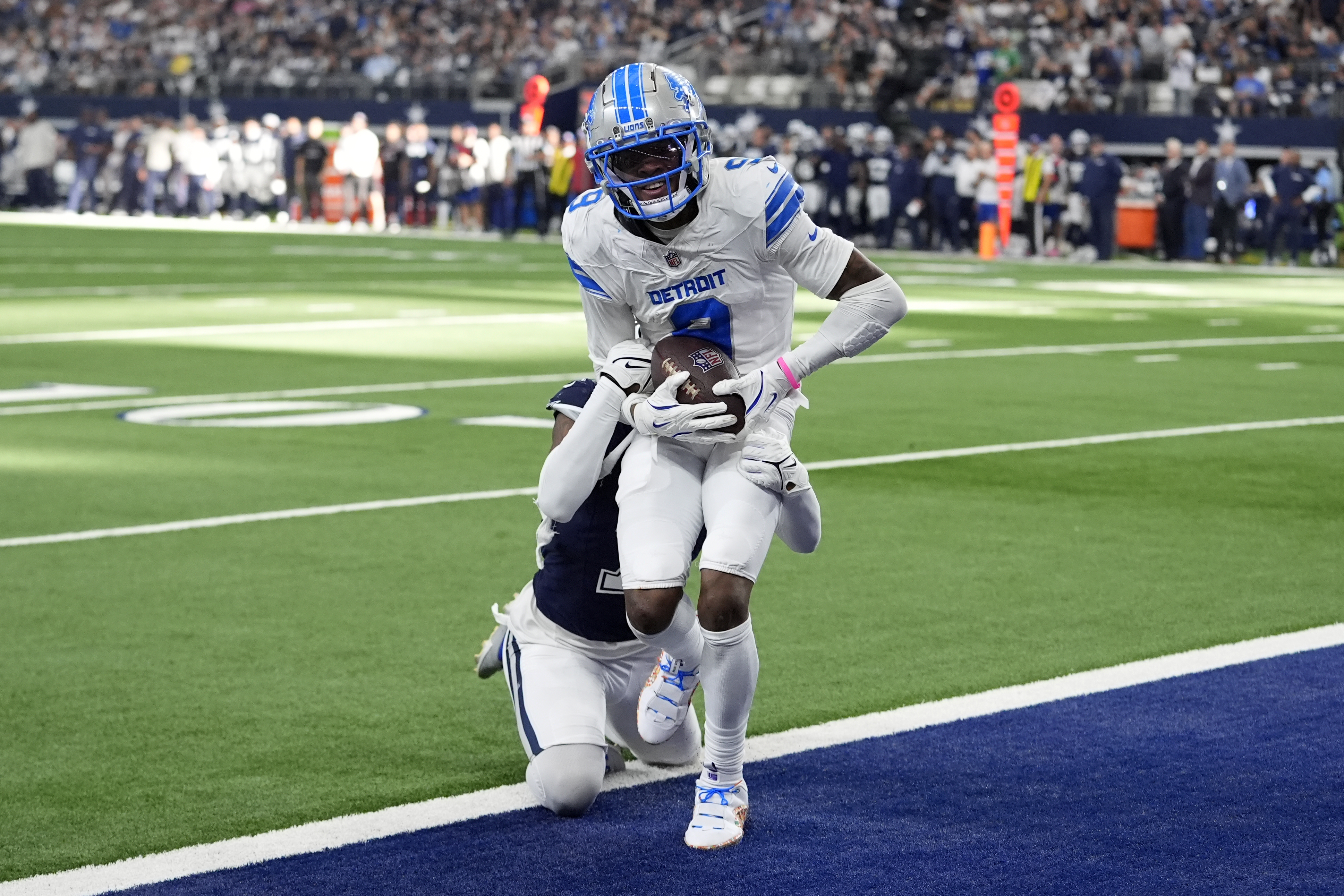 Detroit Lions wide receiver Jameson Williams (9) catches a touchdown pass as Dallas Cowboys cornerback Trevon Diggs, rear, defends in the second half of an NFL football game in Arlington, Texas, Sunday, Oct. 13, 2024. 