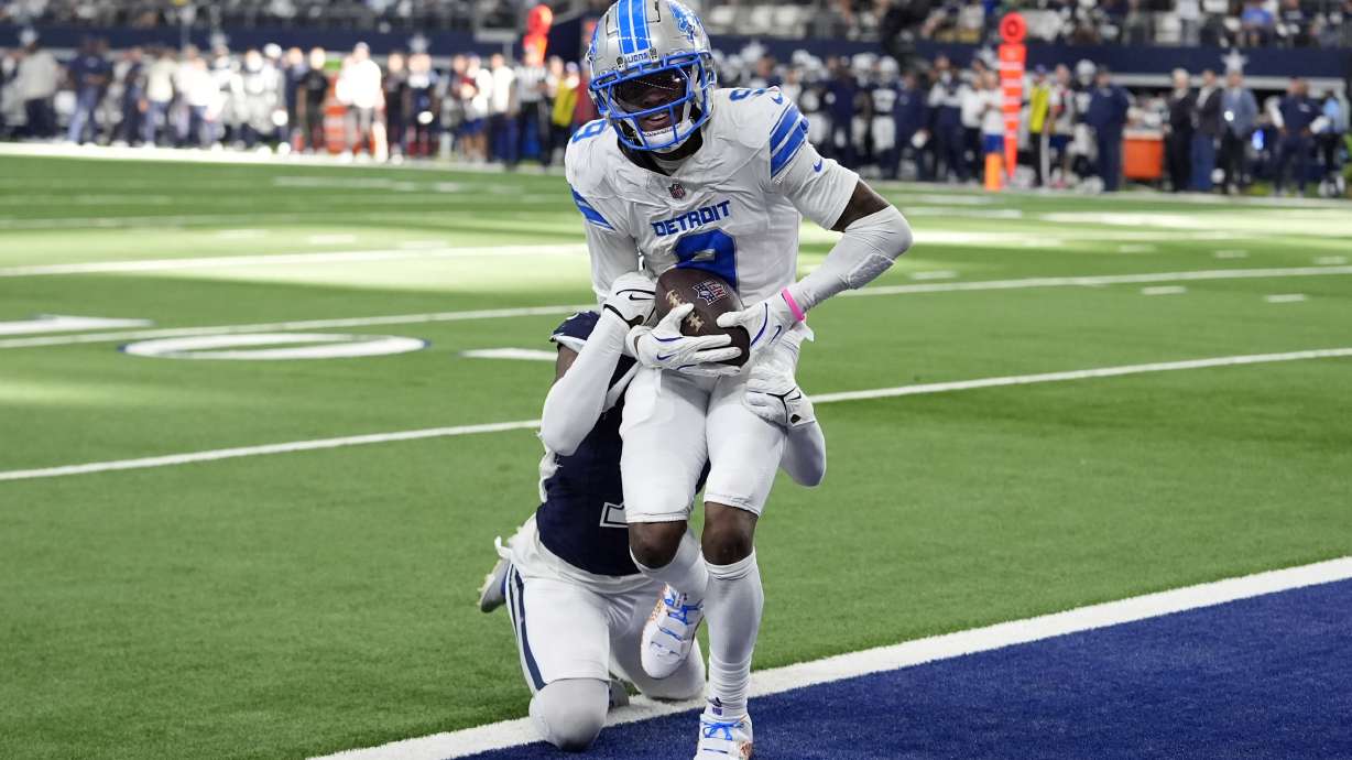 Detroit Lions wide receiver Jameson Williams (9) catches a touchdown pass as Dallas Cowboys cornerback Trevon Diggs, rear, defends in the second half of an NFL football game in Arlington, Texas, Sunday, Oct. 13, 2024.