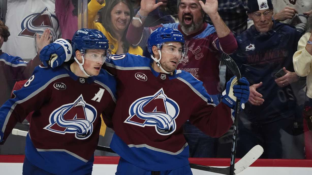 Colorado Avalanche defenseman Cale Makar, left, congratulates center Ross Colton after his goal against the Ottawa Senators in the third period of an NHL hockey game Sunday, Oct. 27, 2024, in Denver.