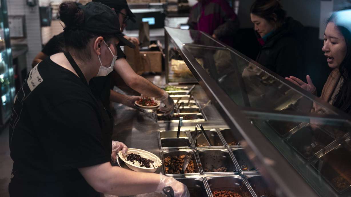 Workers serve food inside a Chipotle restaurant in New York on Jan. 12. Chipotle customers have complained that portion sizes are all over the map. The company finally has a solution – "consistent and generous portions."