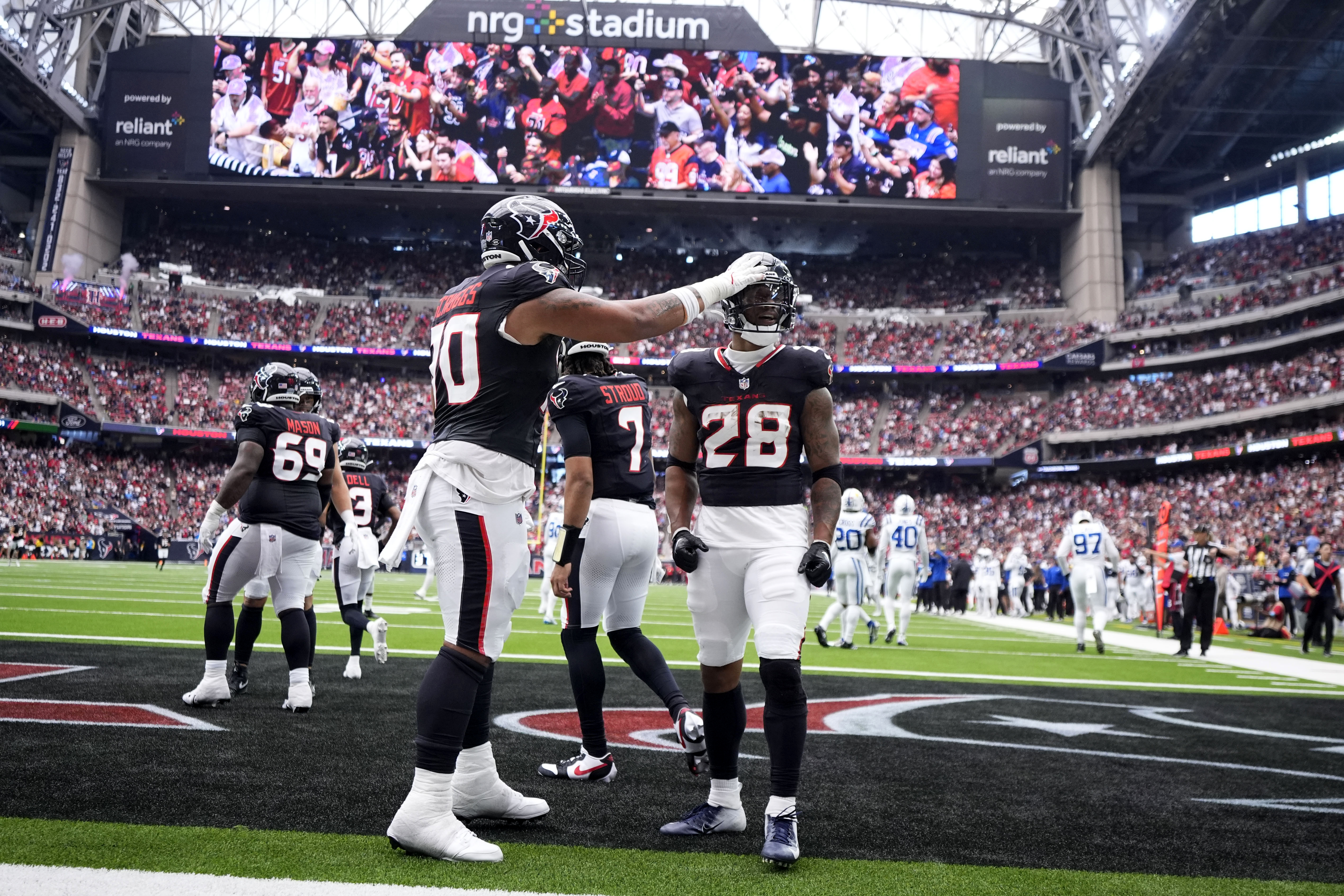 Houston Texans running back Joe Mixon (28) celebrates with teammate Juice Scruggs (70) after a 14-yard touchdown run during the first half of an NFL football game against the Indianapolis Colts, Sunday, Oct. 27, 2024, in Houston. 