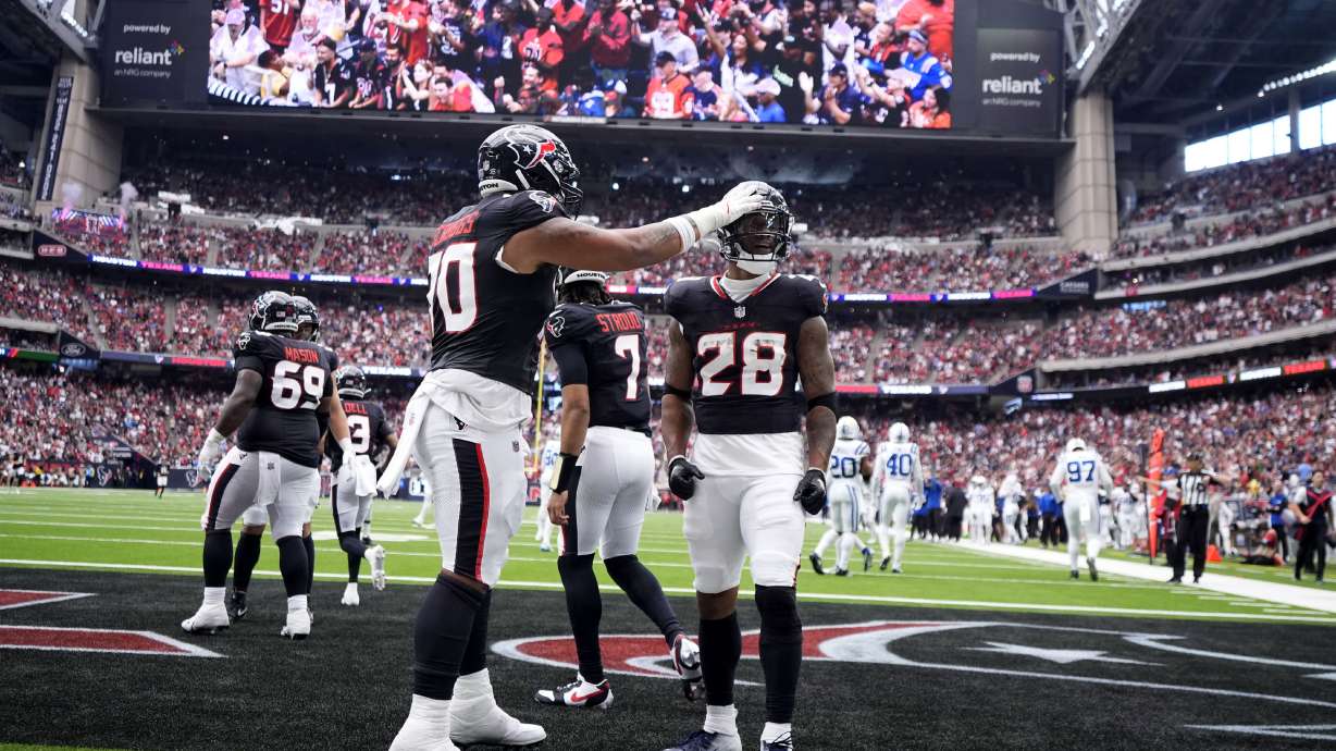 Houston Texans running back Joe Mixon (28) celebrates with teammate Juice Scruggs (70) after a 14-yard touchdown run during the first half of an NFL football game against the Indianapolis Colts, Sunday, Oct. 27, 2024, in Houston.